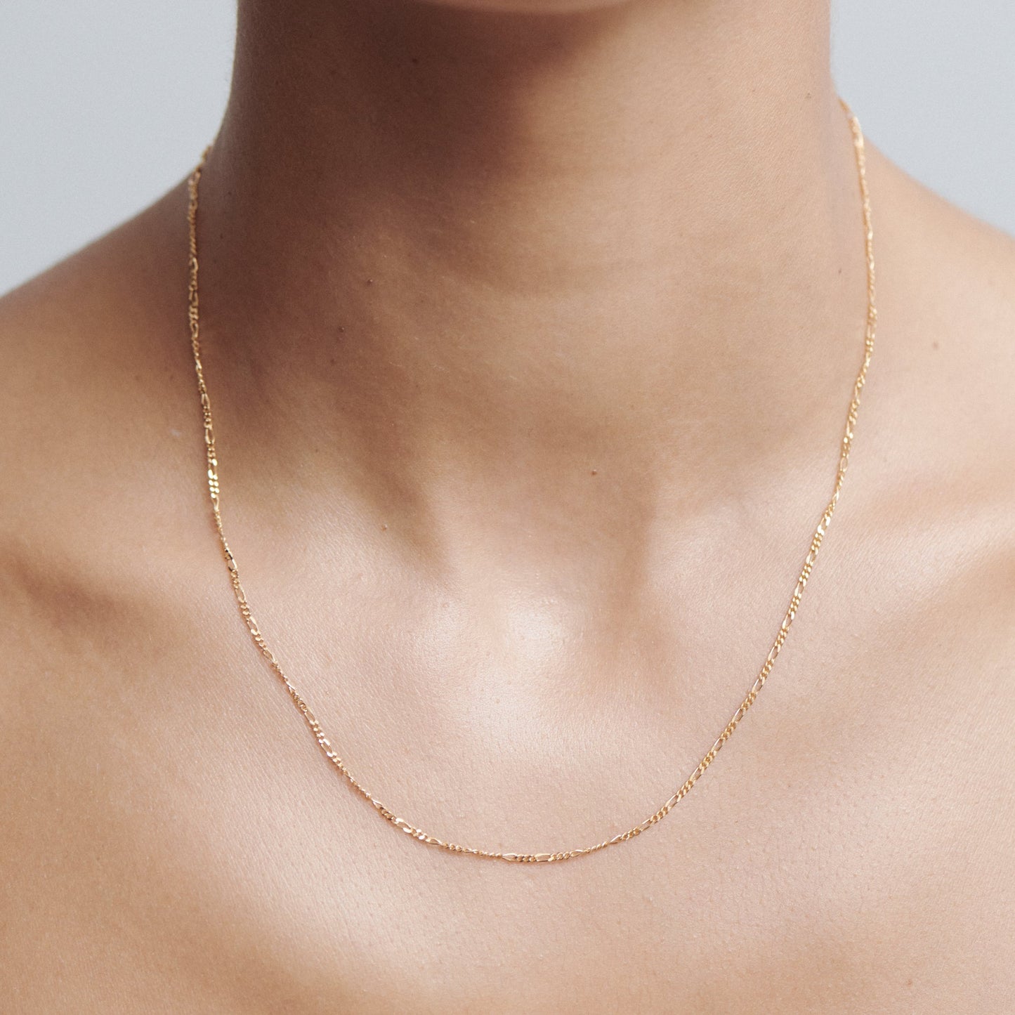 Elegant gold chain necklace worn on a woman's neck. The delicate design enhances luxury aesthetics in fine jewellery.