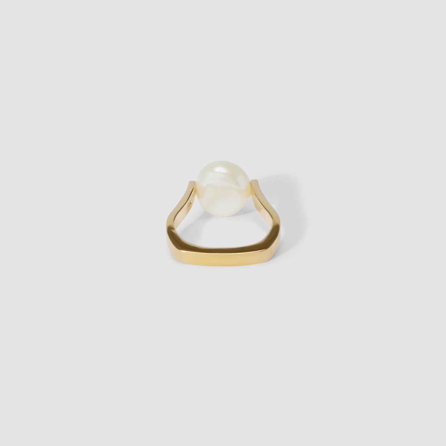 Gold ring featuring a single pearl, set on a modern, geometric band. Luxury jewellery design on a plain grey background.