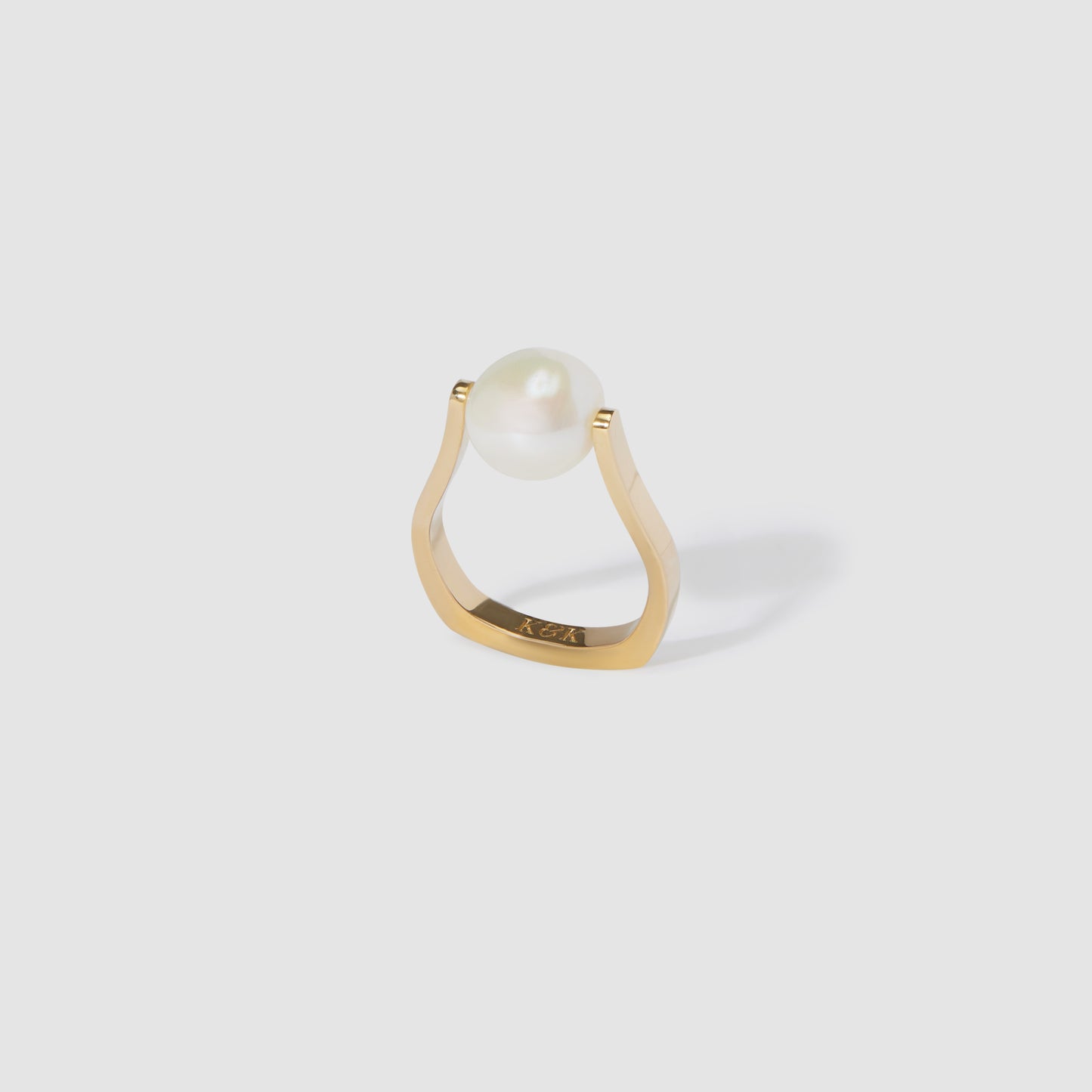 Gold ring with minimalist design showcasing a single white pearl.