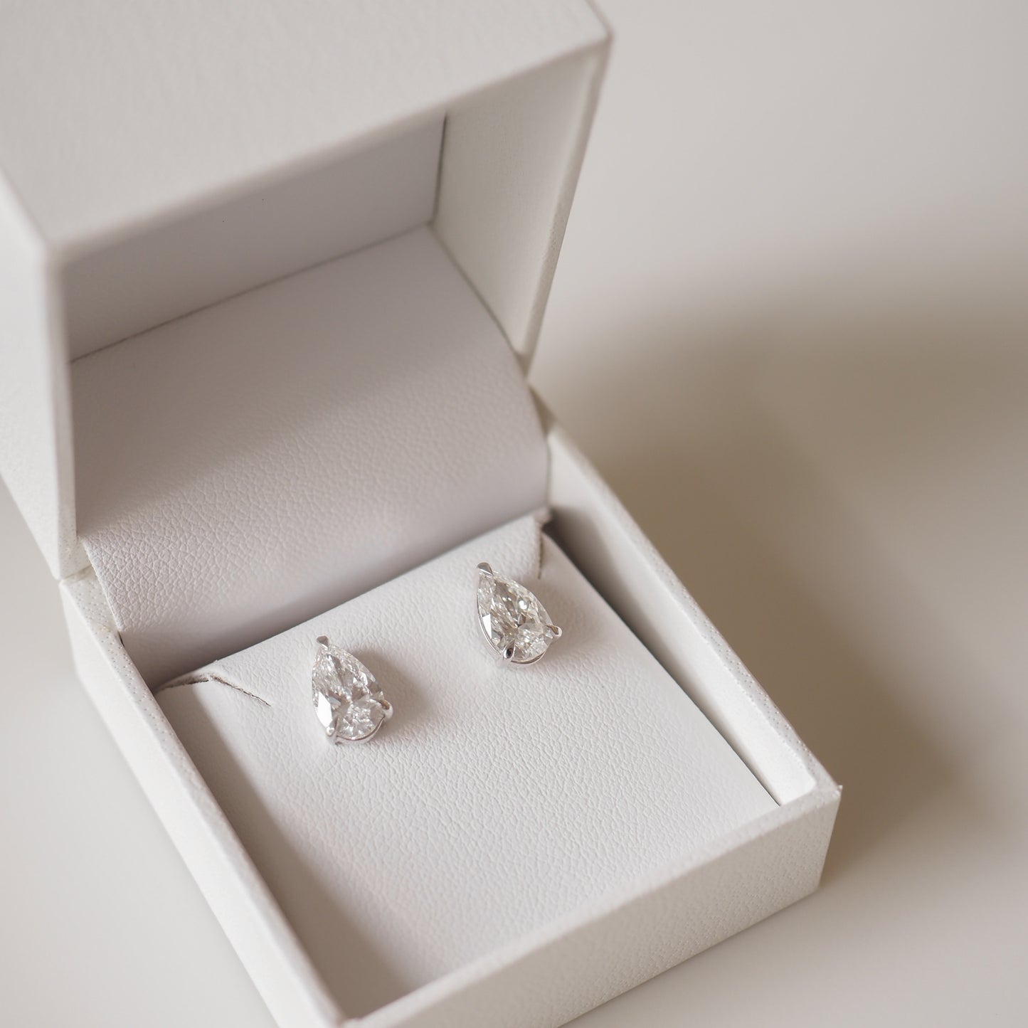 Pear-shaped diamond earrings in an elegant white jewellery box, perfect for luxury gift-giving and special occasions.
