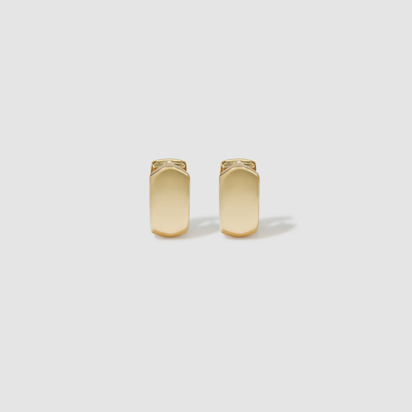 Elegant gold rectangular cufflinks on a plain grey background, perfect for formal luxury fashion and adding a sophisticated touch.