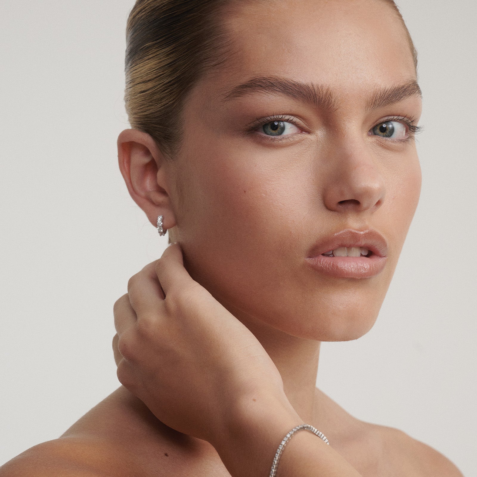 Woman wearing earrings with a neutral background