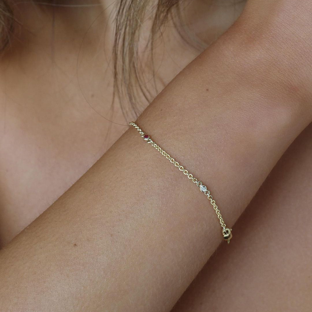 Elegant gold bracelet with small diamonds on a woman's wrist, showcasing luxury jewellery design in a close-up view.