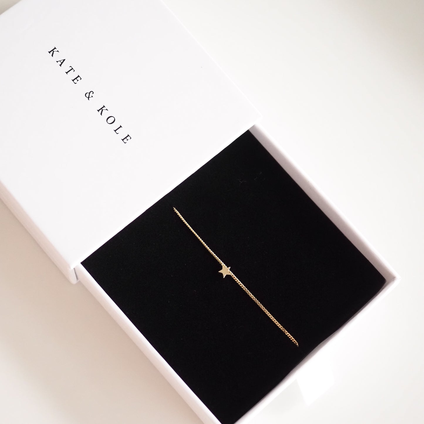 Gold bracelet with star charm displayed in an elegant Kate & Kole jewellery box; minimalist luxury piece on a black velvet base.