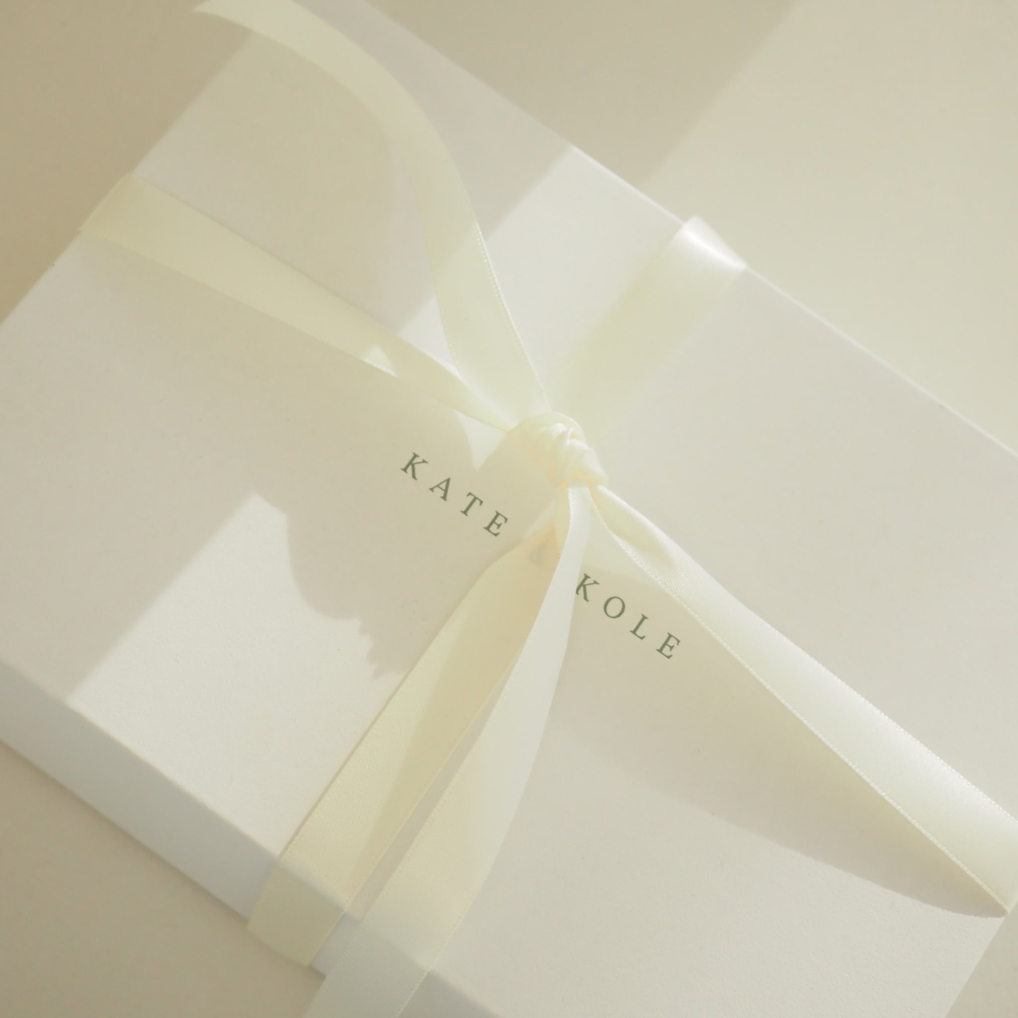 Close-up of a folded white paper with 'KATE KOLE' branding.