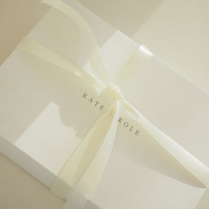 Close-up of a folded white paper with 'KATE KOLE' branding.