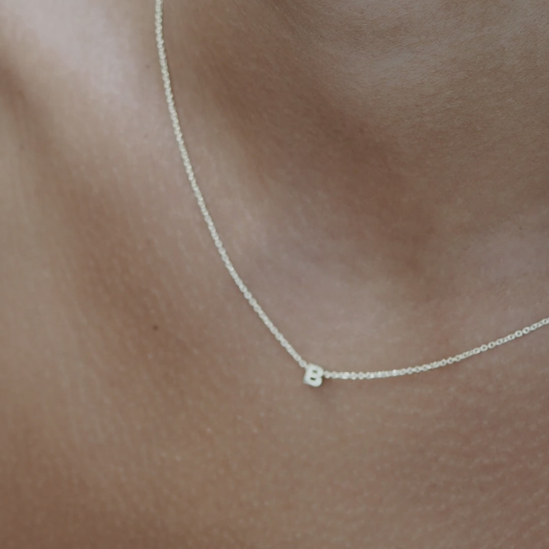Solid gold and sterling silver jewellery: Video of a model wearing our signature sterling silver tiny letter B charm necklace on a 40cm cable chain