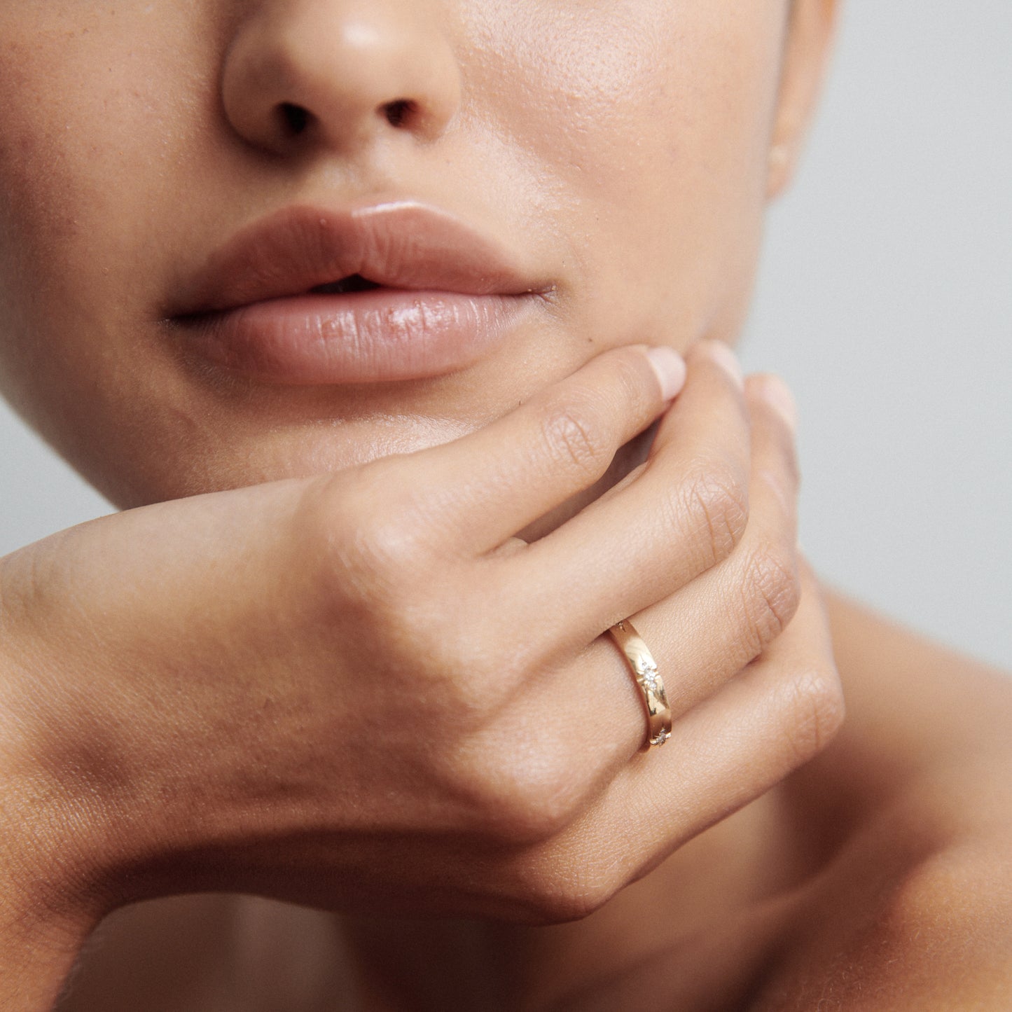 Close-up of a woman's hand featuring a luxurious gold ring with delicate engravings, highlighting elegance and sophistication in jewellery.