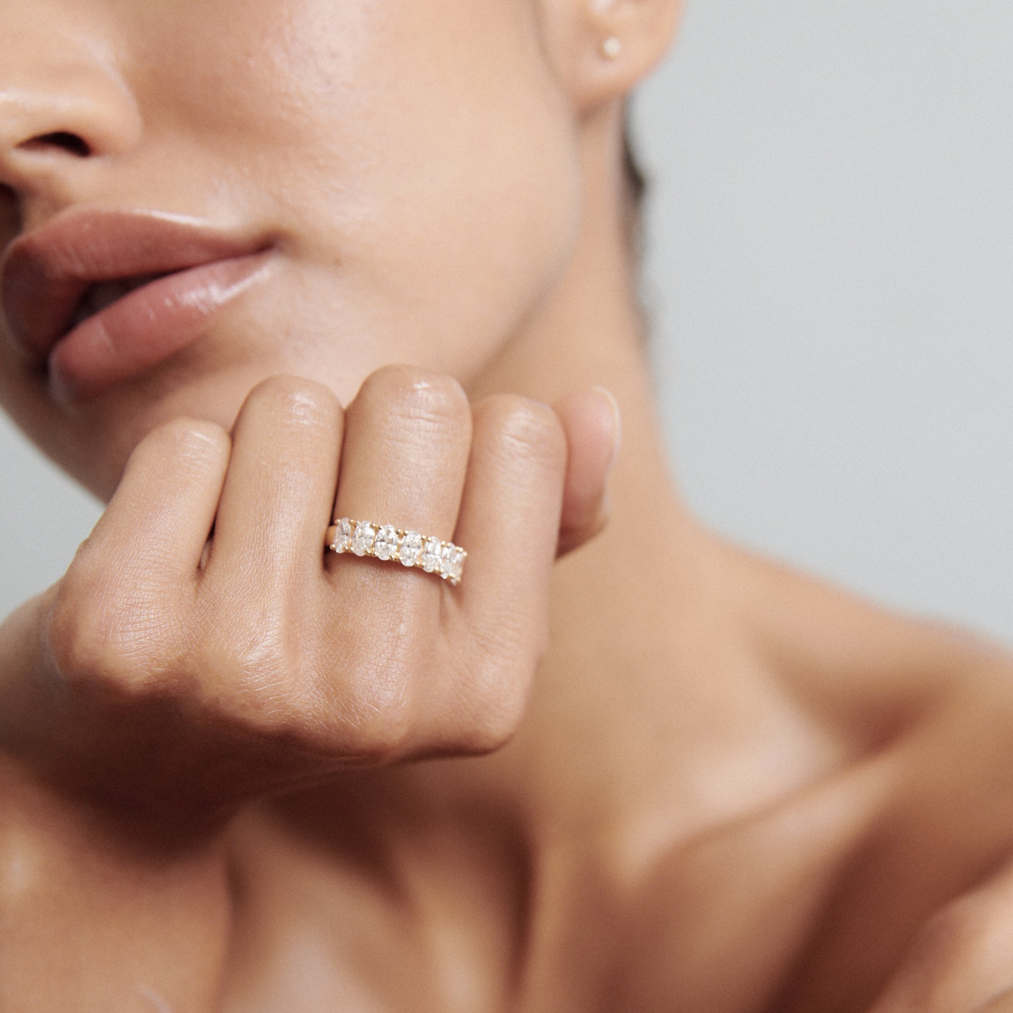 Close-up of a person showcasing a diamond eternity ring on their finger, highlighting luxurious jewellery and elegance.