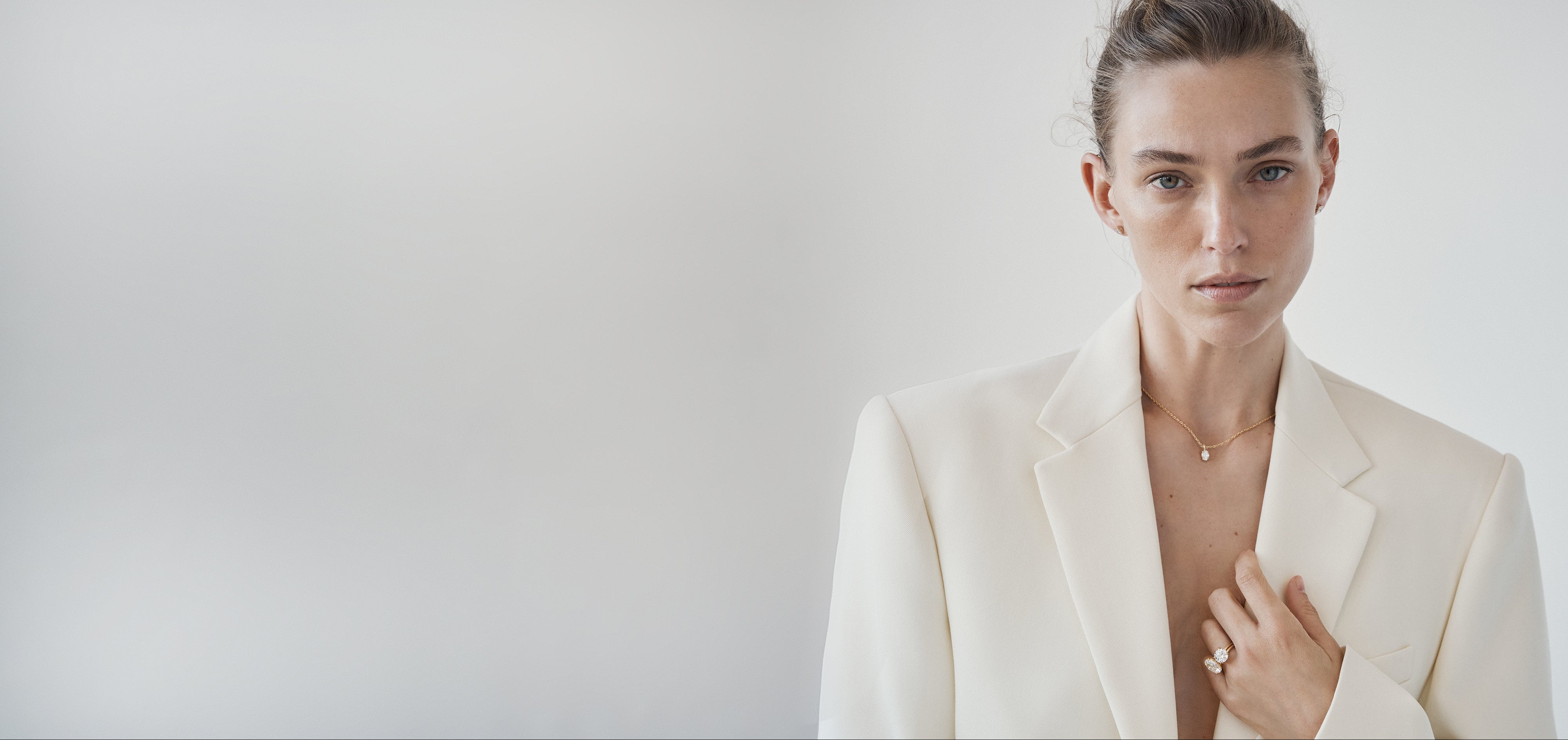 Woman wearing a white blazer against a plain background