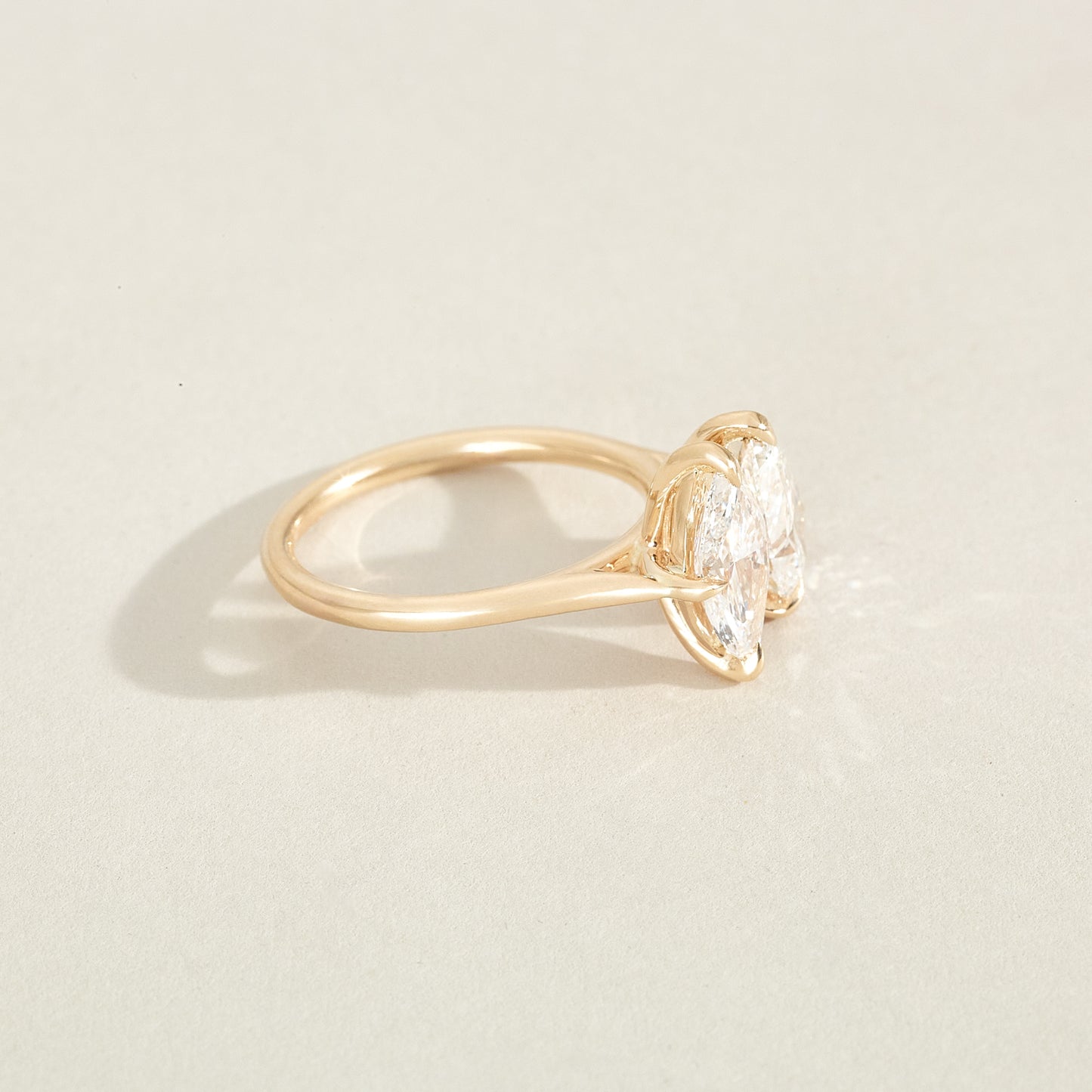 Gold ring with a diamond on a light beige background