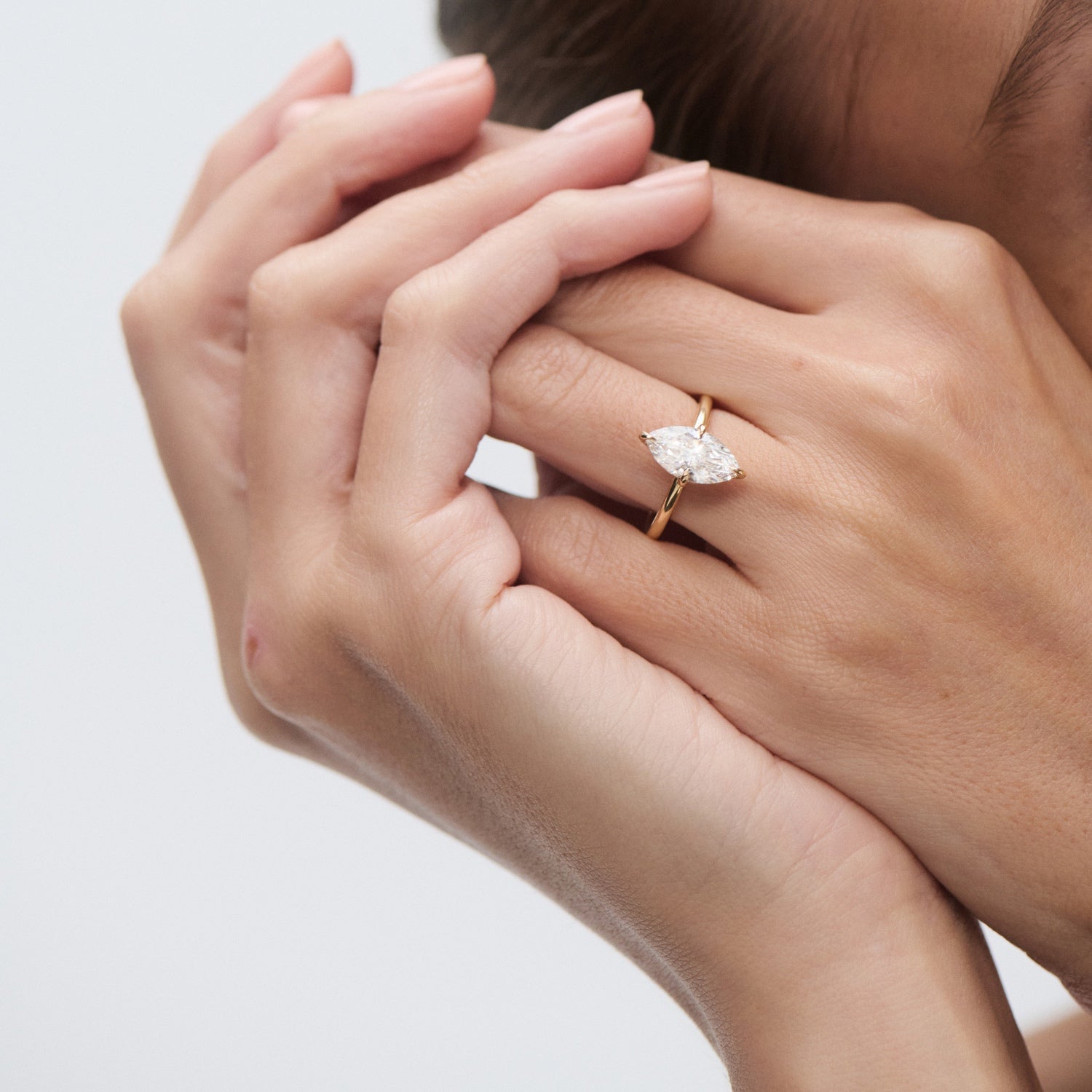 Elegant marquise diamond ring on a woman's hand, set in gold. Luxurious and refined jewellery design, ideal for engagement or special occasions.