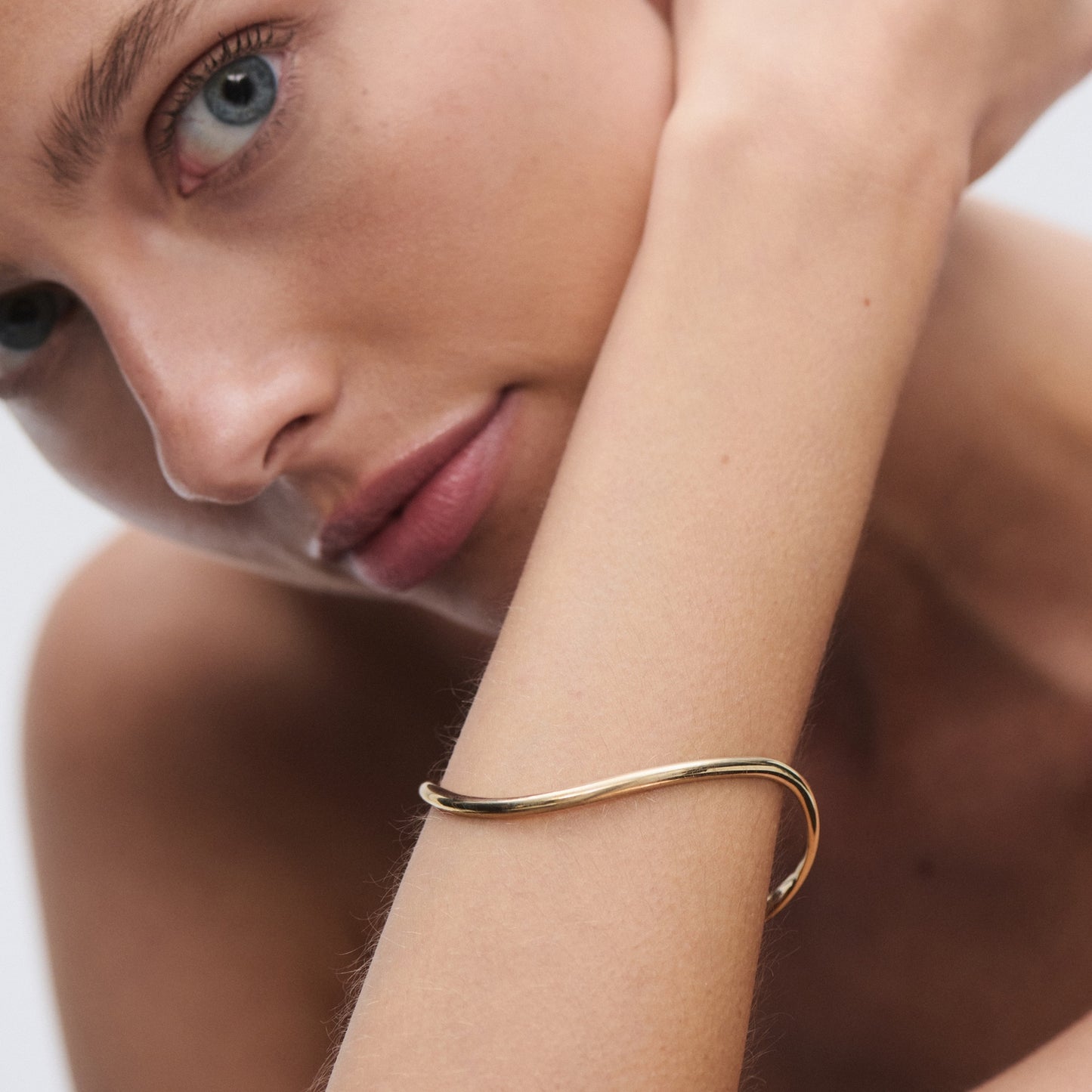 Elegant gold bracelet on a woman's arm, with a close-up showcasing minimalist design and luxury jewellery aesthetics.