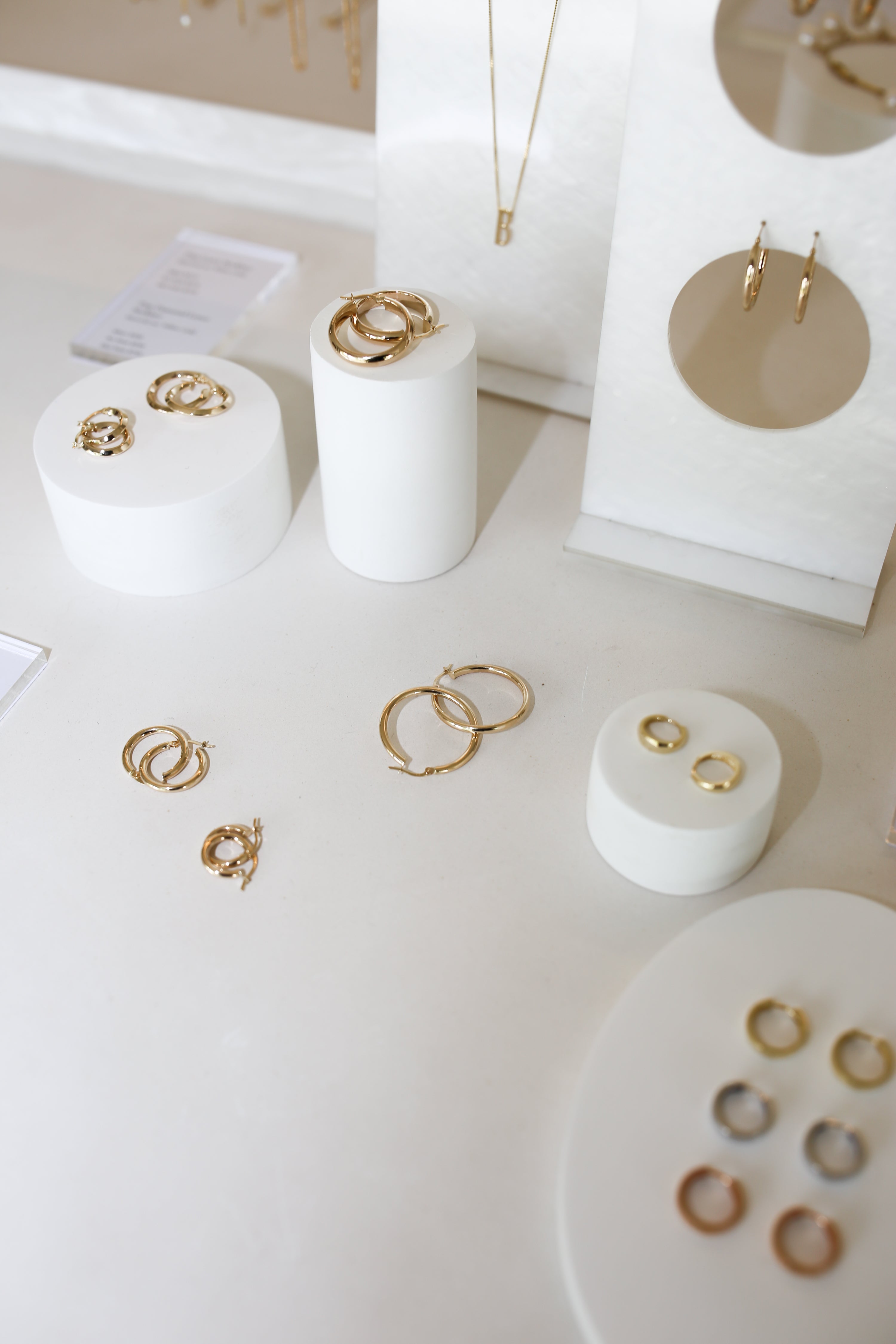 Luxurious gold jewellery display with rings and earrings on white stands, showcasing elegance and sophistication in high-end Australian jewellery.