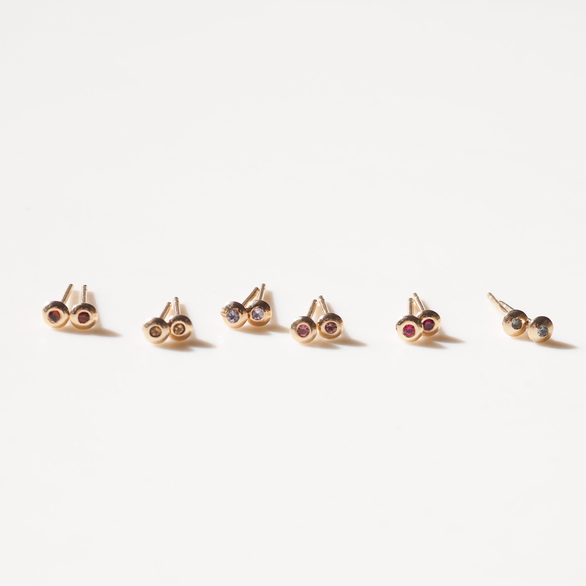 Yellow gold studs with colourful gemstones in the centre