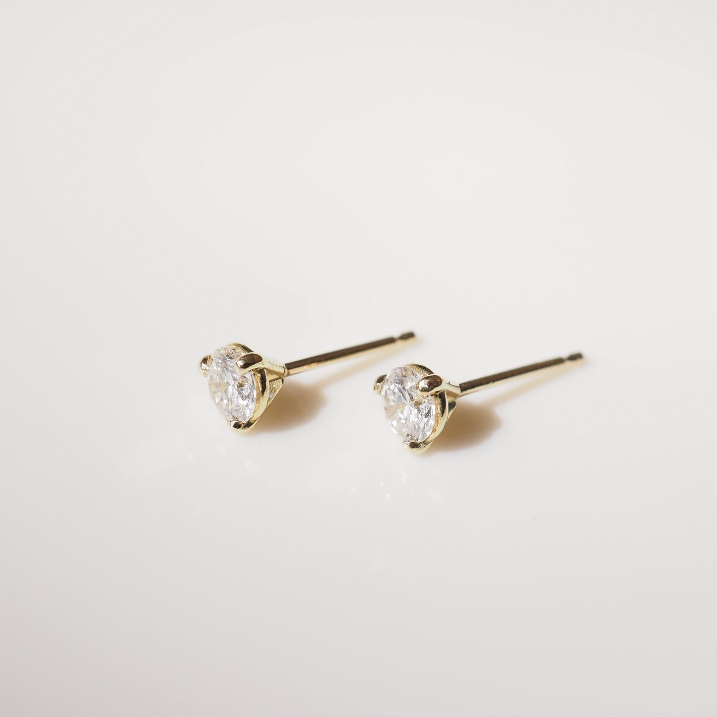 Diamond stud earrings on a light gray background
