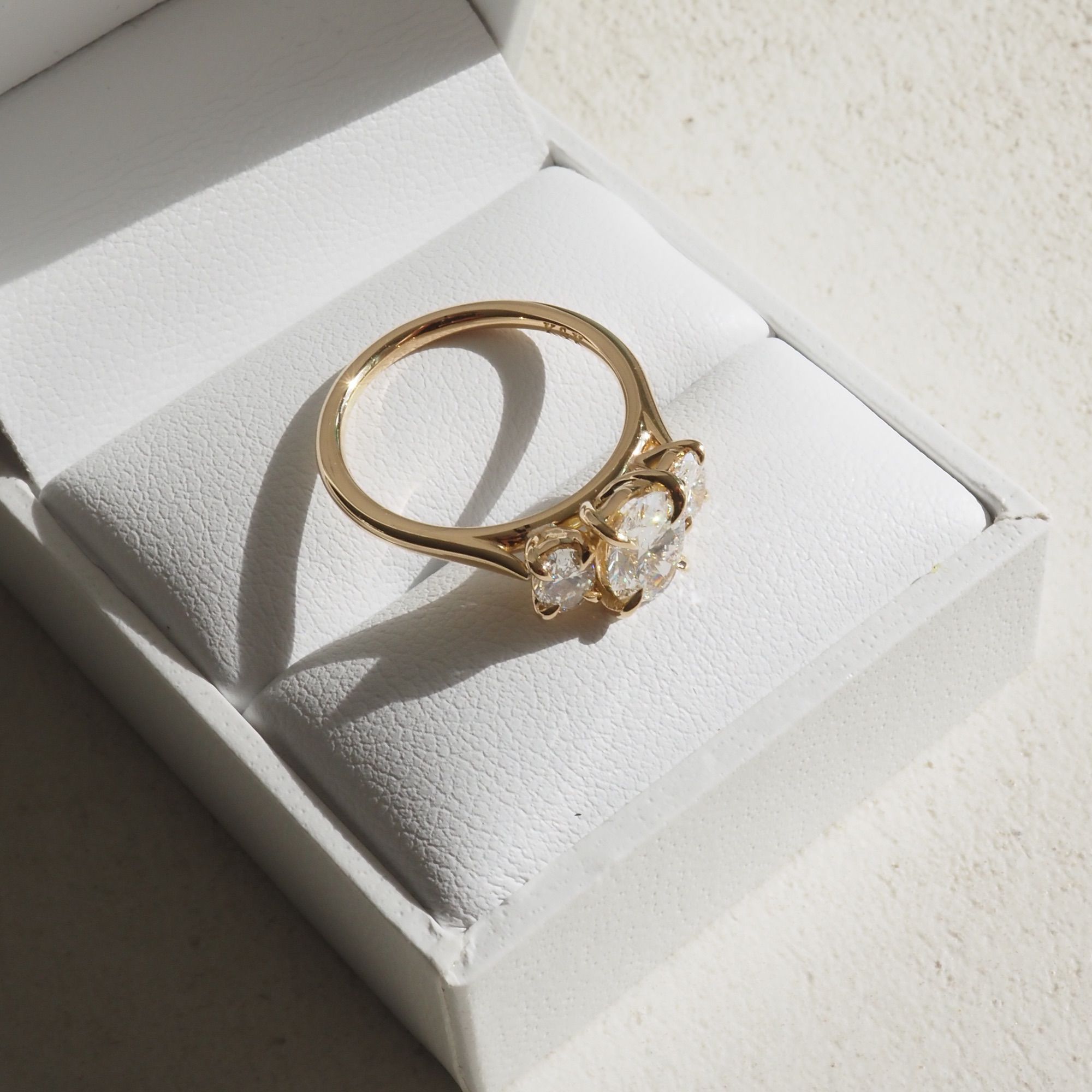 Our Ava ring showcases a brilliant oval cut centre stone shining between two smaller-sized shoulder stones. The centre stone size pictured is 1.02ct and the shoulder stones are 0.25ct each.