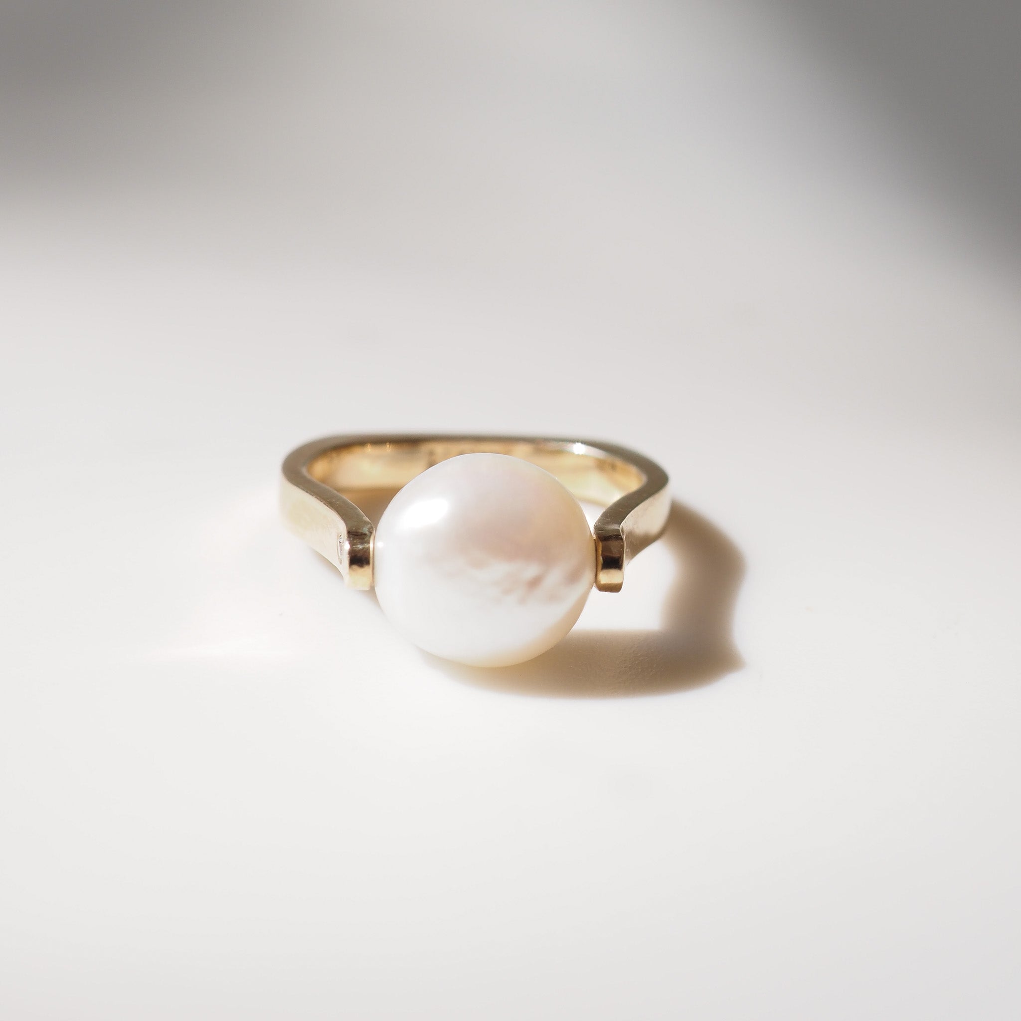 Pearl ring on light grey background