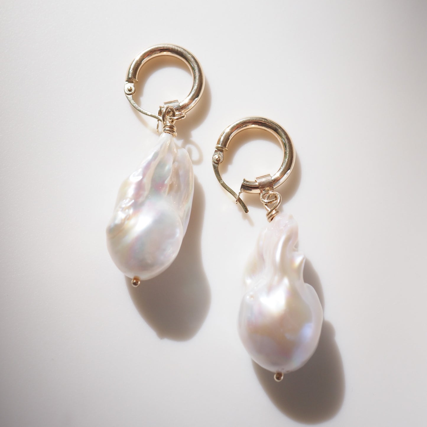Gold Pearl Earrings on a cream background