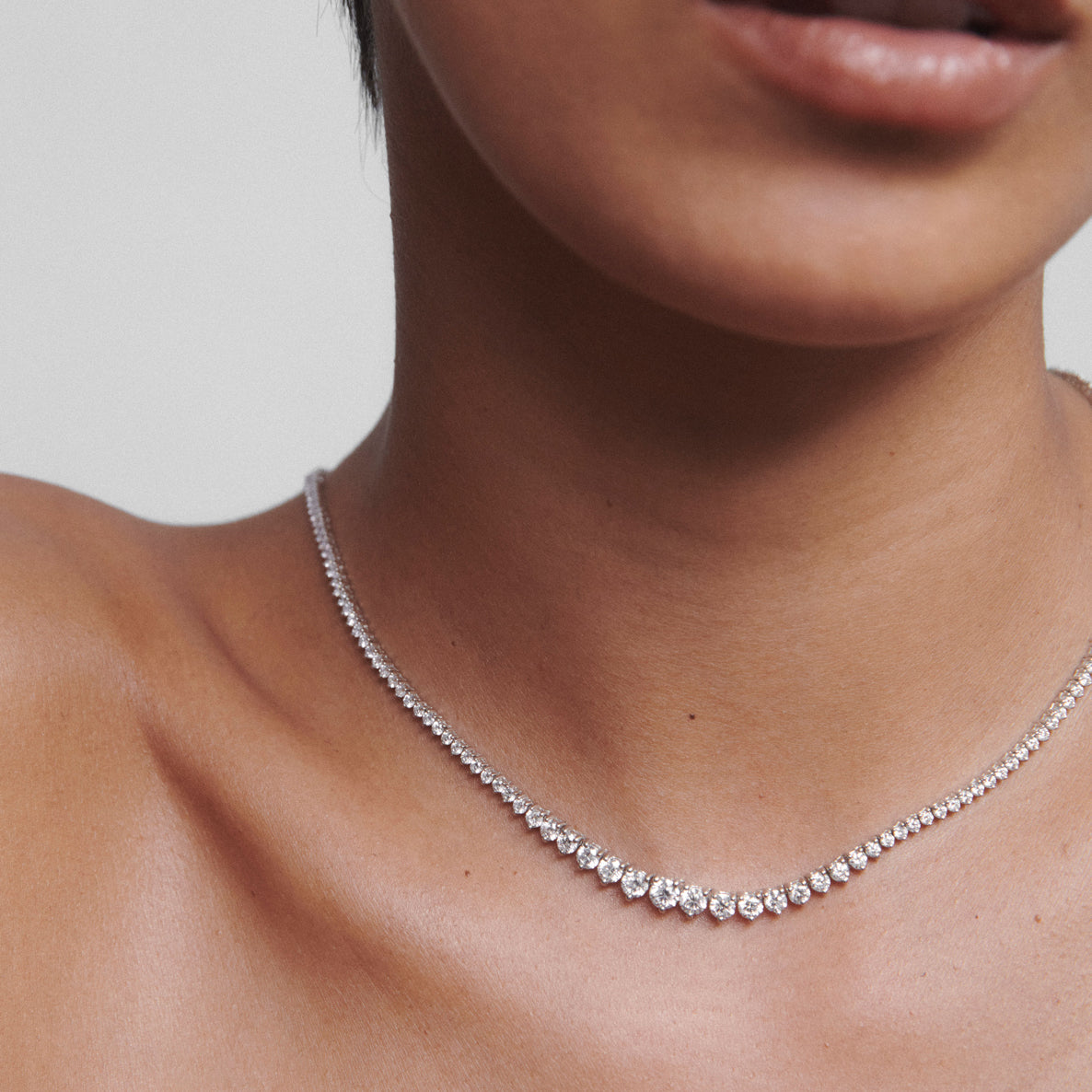 Elegant diamond necklace elegantly drapes around a woman's neck, showcasing luxury jewellery and sophisticated style.