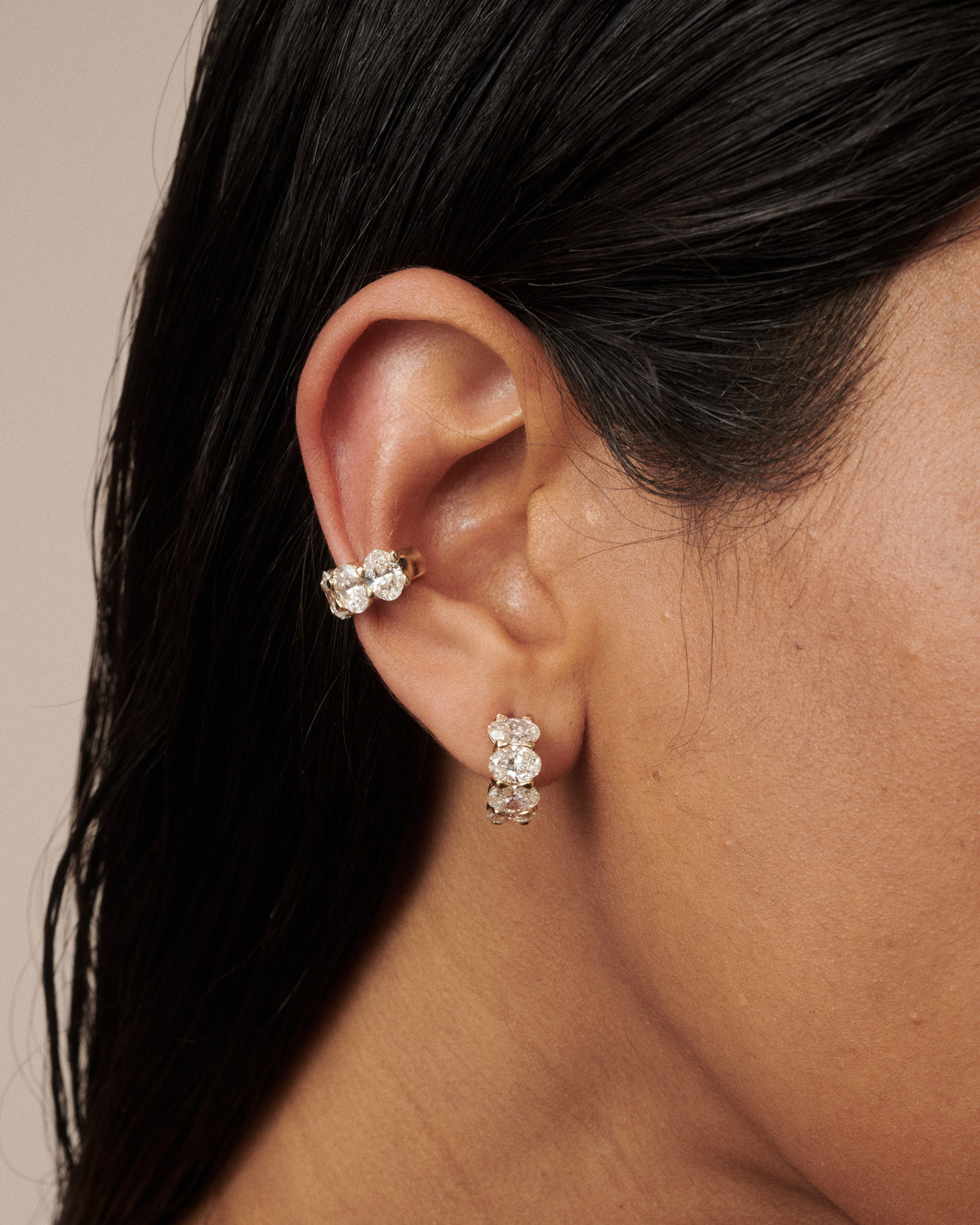 Gold oval lab-grown diamond cuff earring with clustered stones, worn on ear