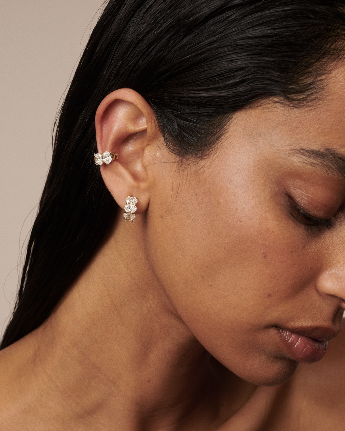 Gold oval lab-grown diamond ear cuff and drop stud earrings, close-up on ear