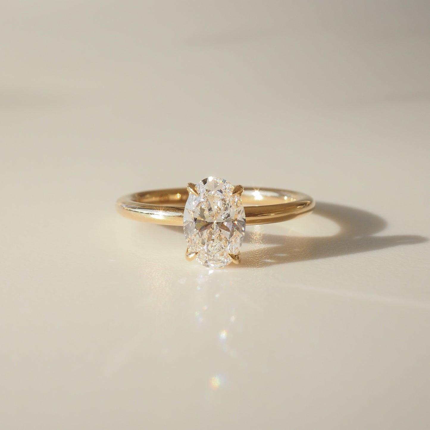 Elegant gold ring with an oval-cut diamond, sparkling under soft lighting, showcasing luxury jewellery craftsmanship.