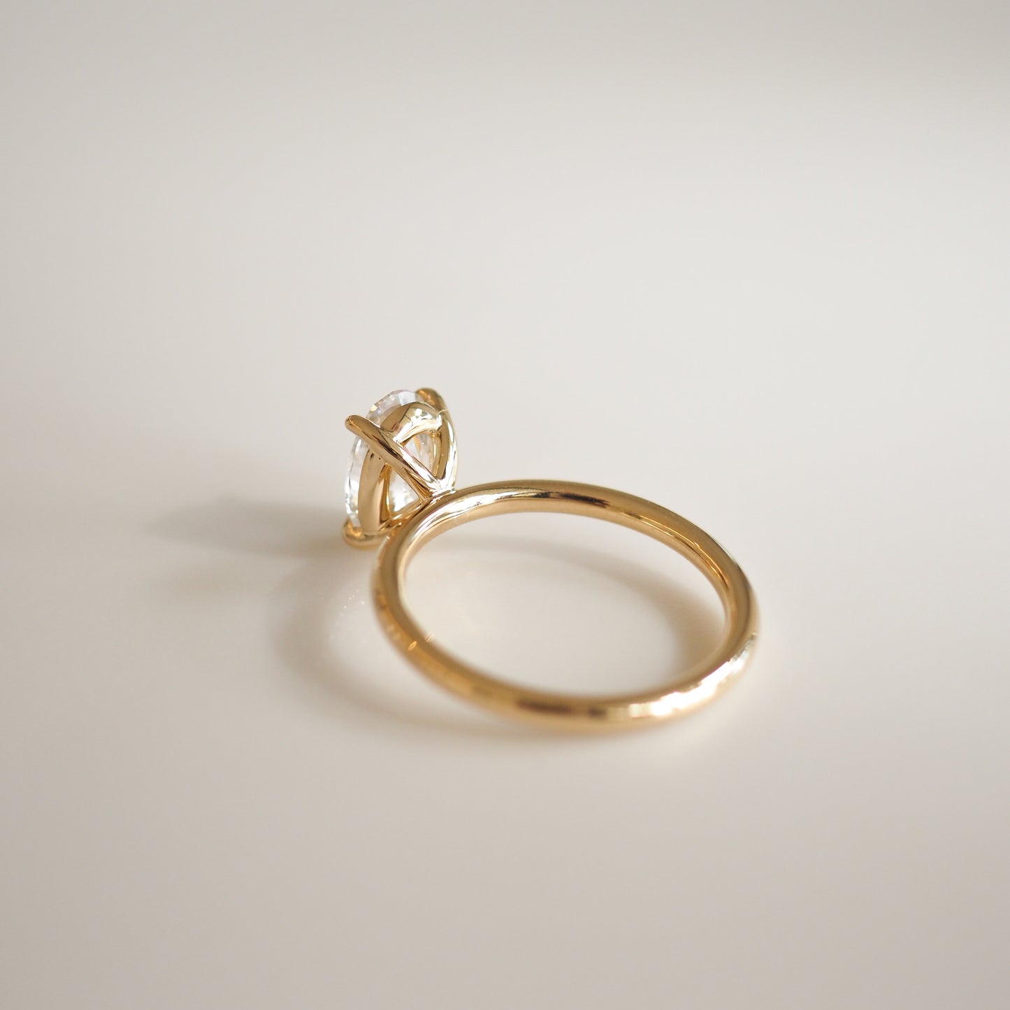 Elegant gold ring with a large, clear gemstone set in a prong setting on a neutral background, highlighting luxury jewellery craftsmanship.