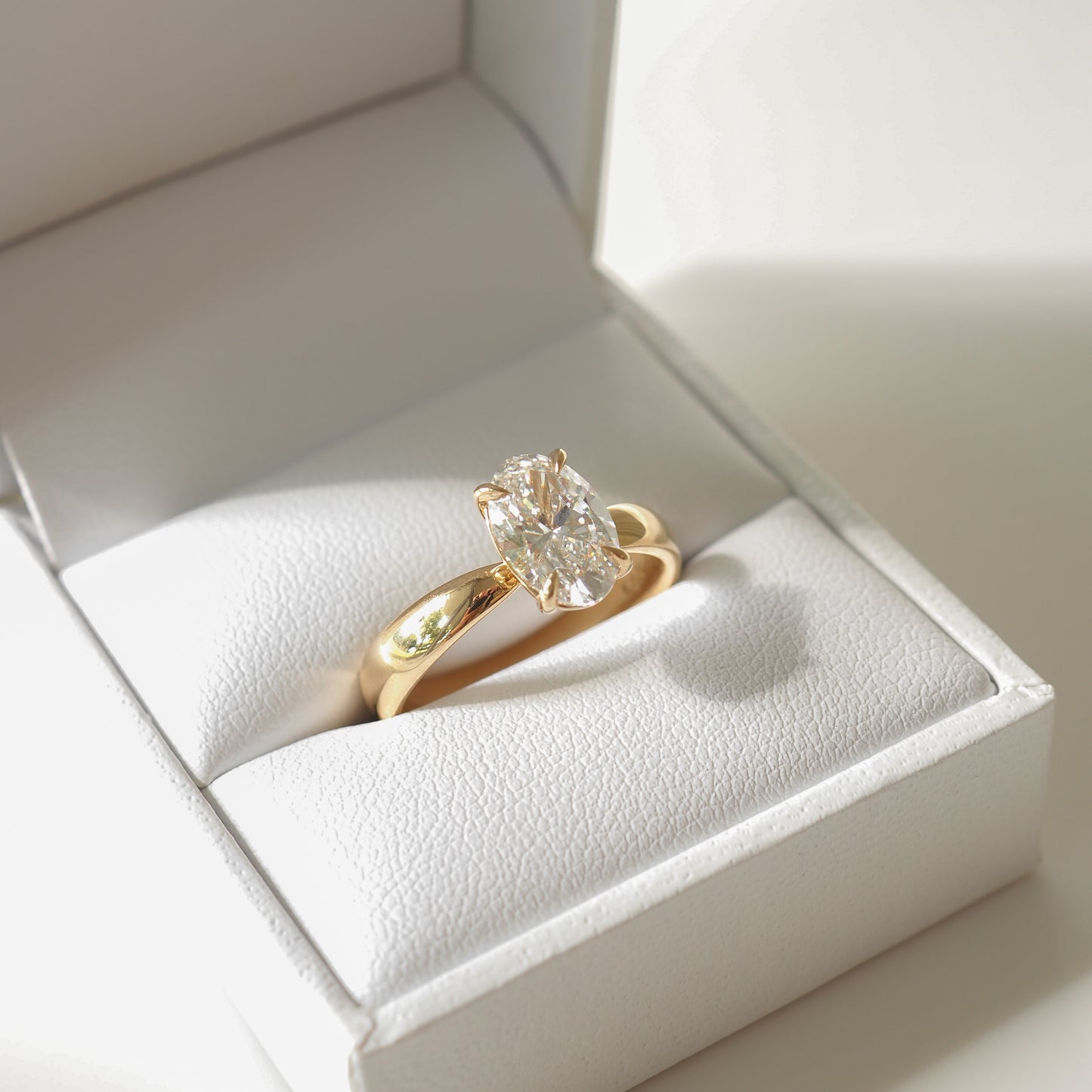 Gold ring with large oval diamond in white jewellery box. Luxurious, high-end detail. Perfect for Australian fine jewellery lovers.