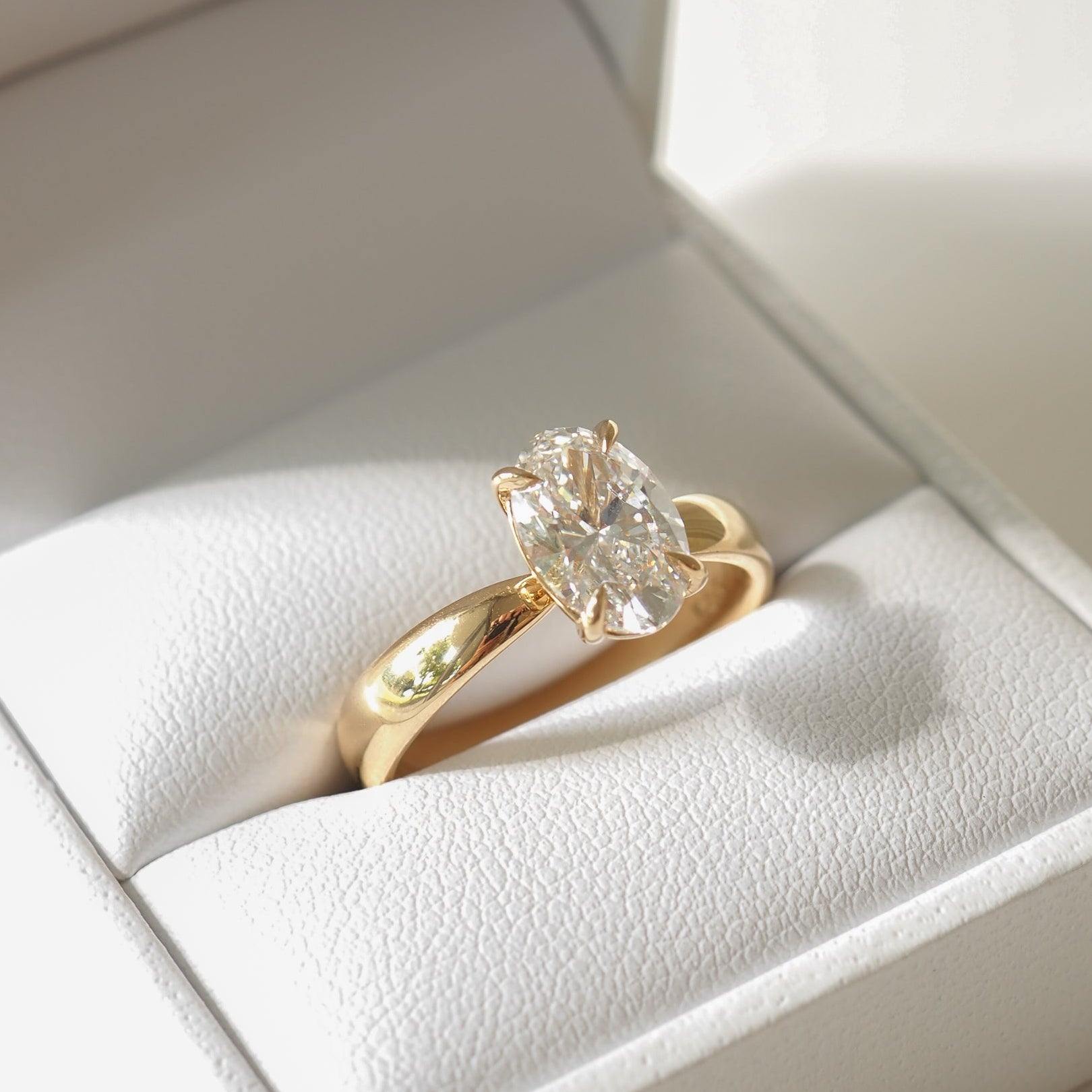 Gold ring with large oval diamond in white jewellery box. Luxurious, high-end detail. Perfect for Australian fine jewellery lovers.