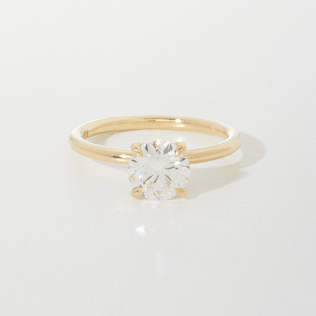 Elegant gold ring with a brilliant-cut diamond solitaire in a classic prong setting, epitomising luxury jewellery design.