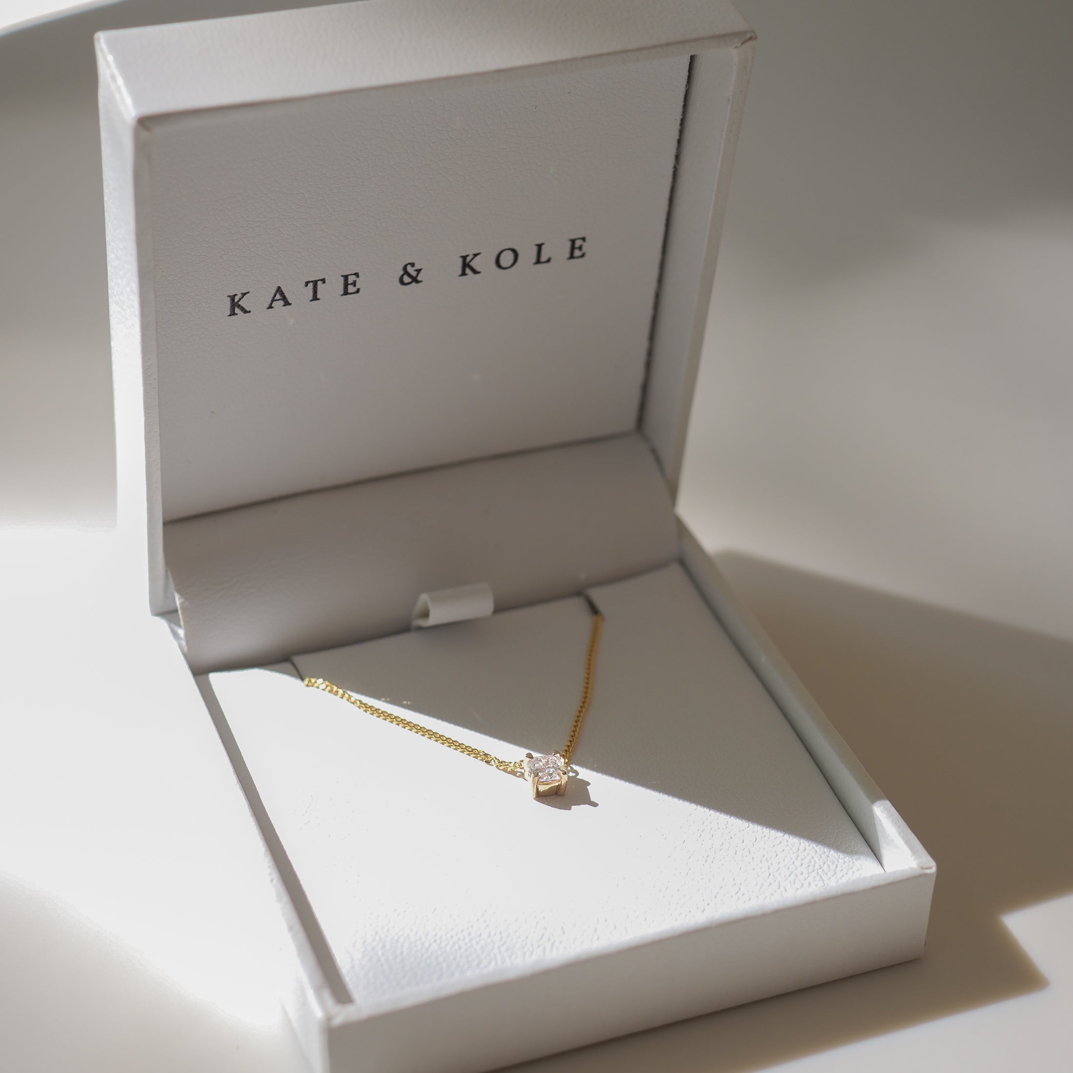 Gold necklace with a diamond pendant displayed in an elegant Kate & Kole jewellery box, showcasing luxury and sophistication.