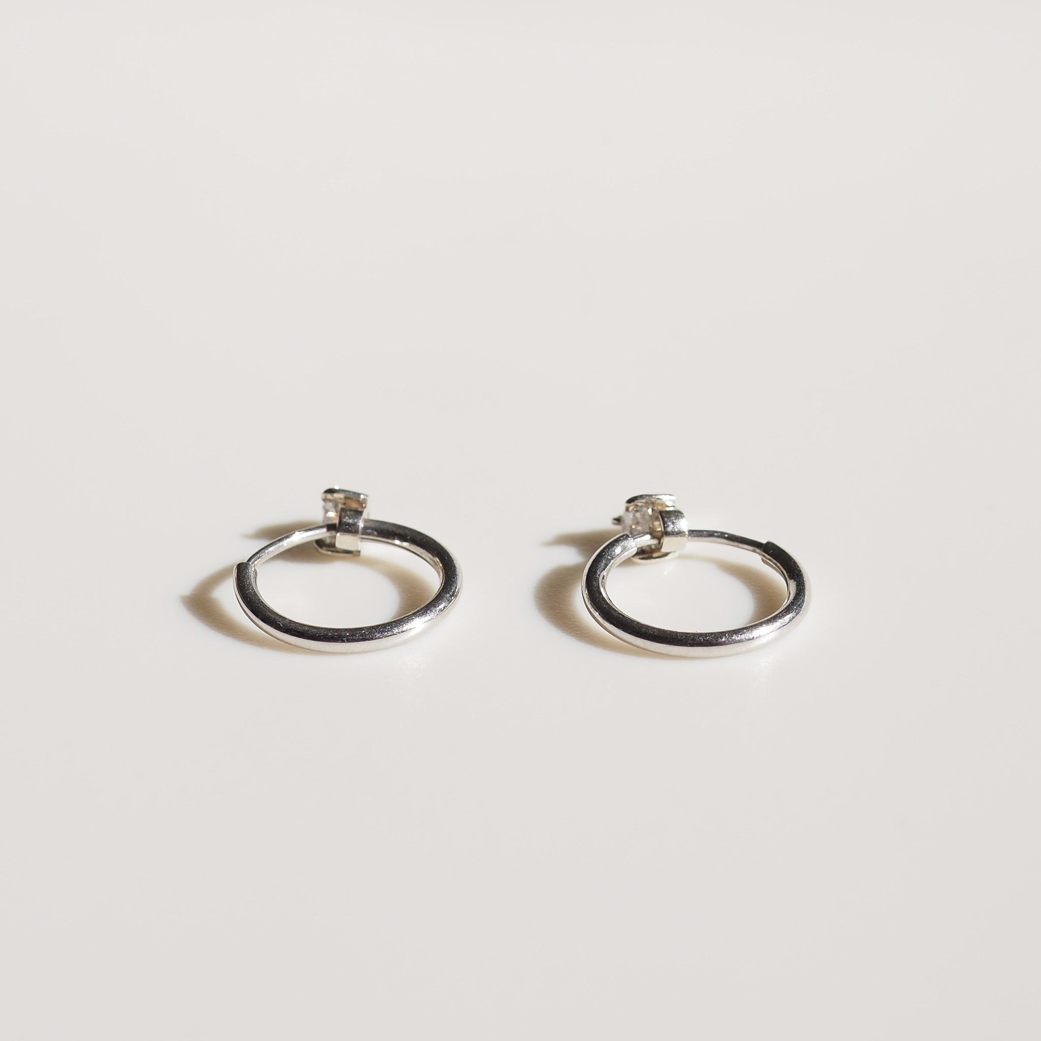 Pair of silver hoop earrings on grey background