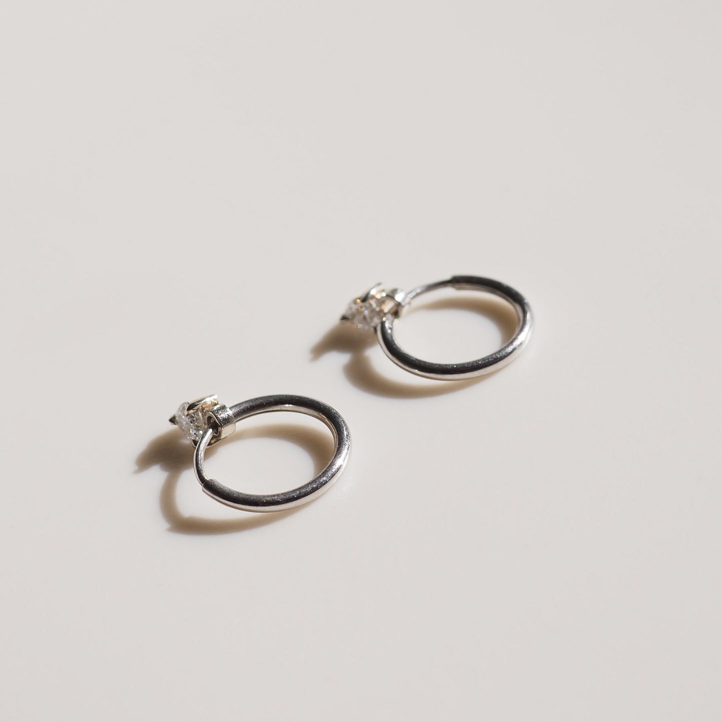 Silver hoop earrings on grey background