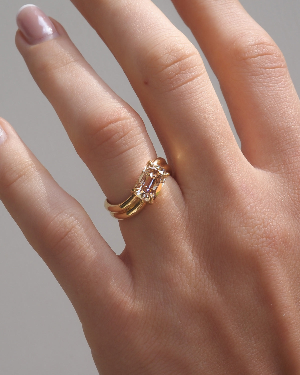 Champagne gold diamond solitaire ring with offset setting on open hand