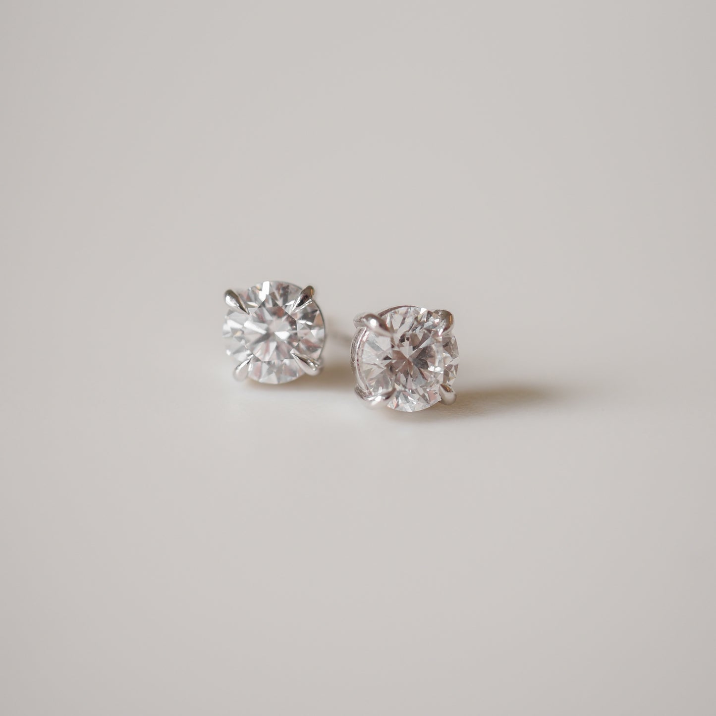 Close-up of elegant diamond stud earrings on a plain white background, highlighting luxury jewellery craftsmanship.