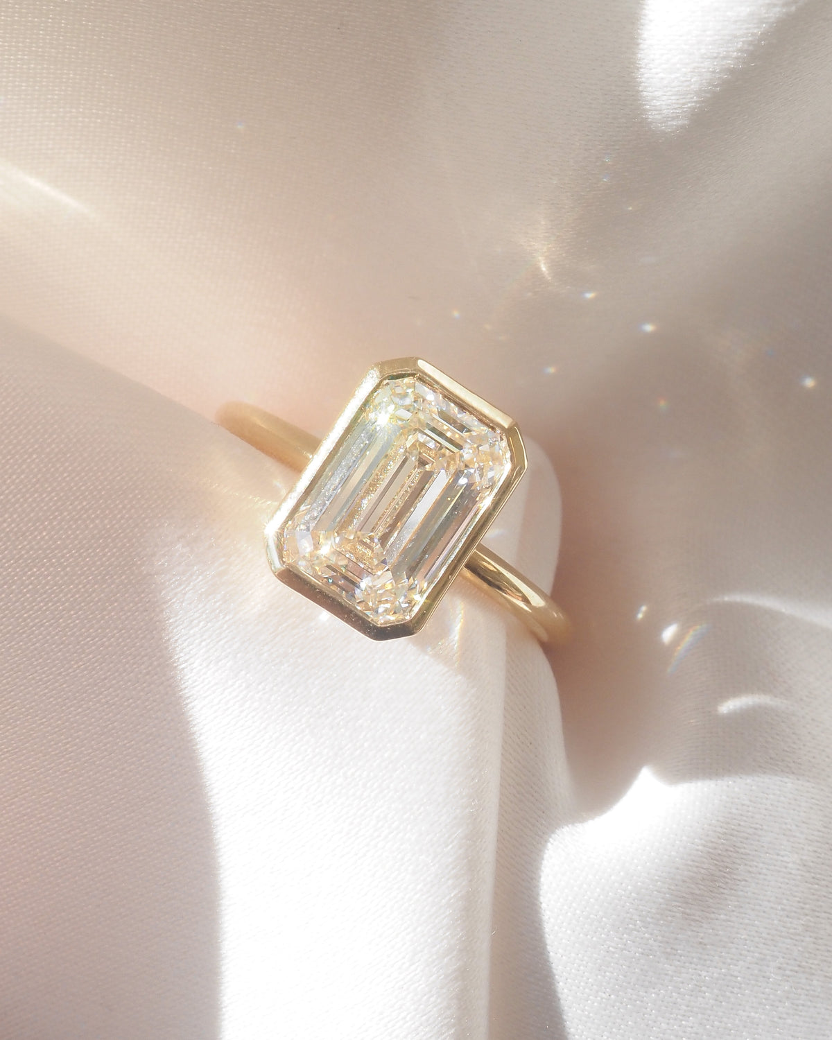 Emerald diamond ring on a gray background