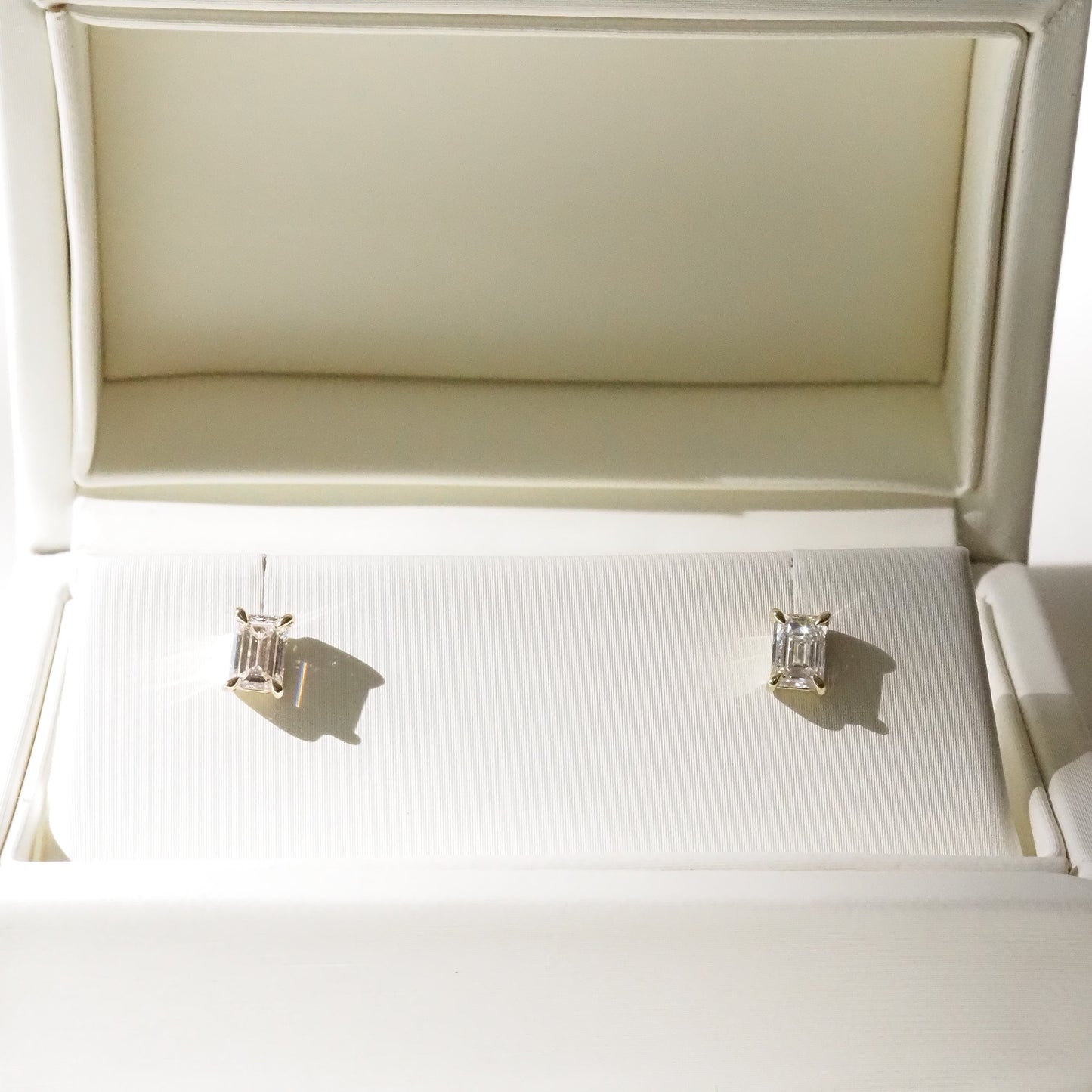 Pair of diamond earrings in a white jewelry box