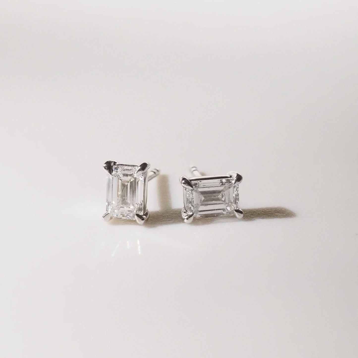 Pair of diamond stud earrings on a light gray background