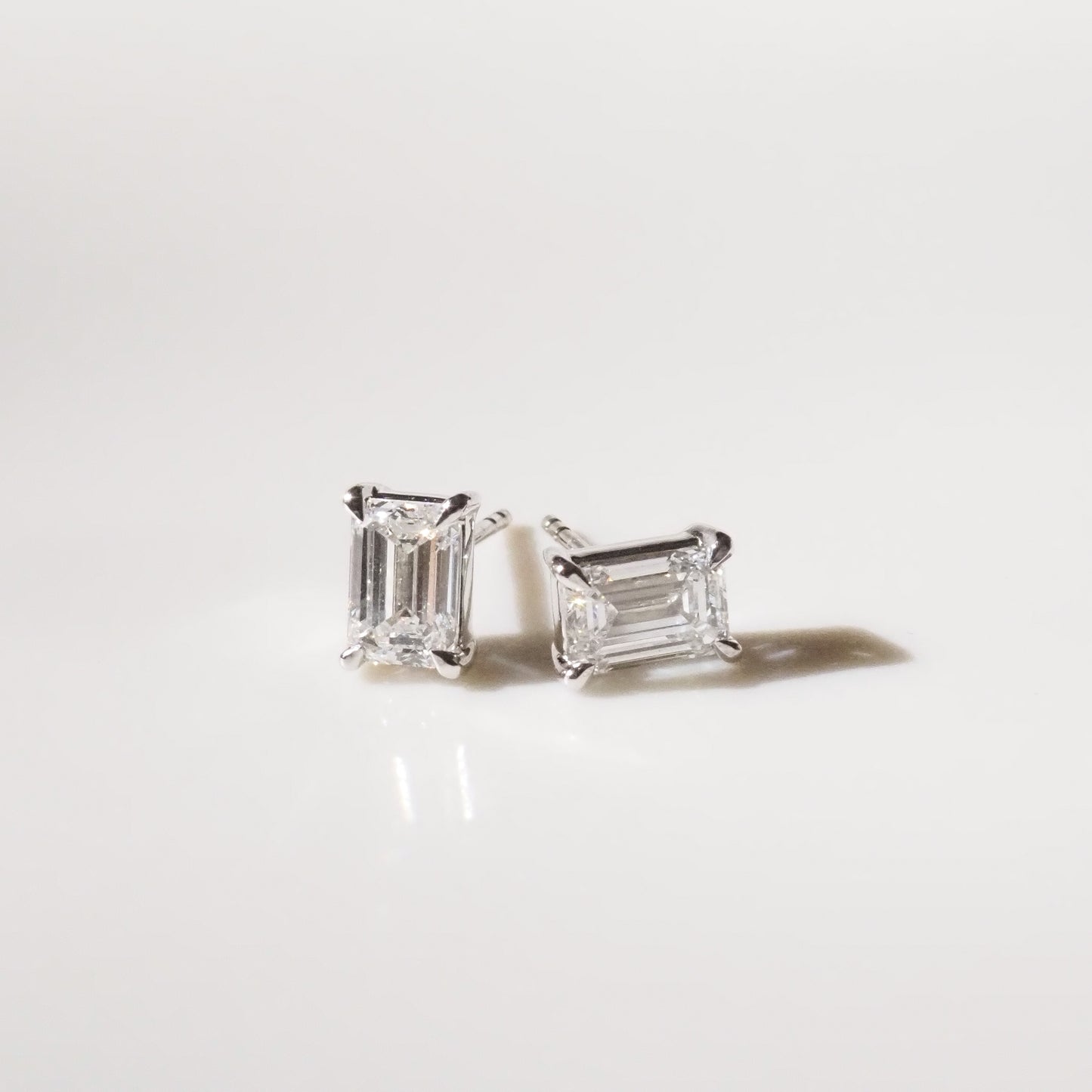 Pair of diamond stud earrings on a light gray background