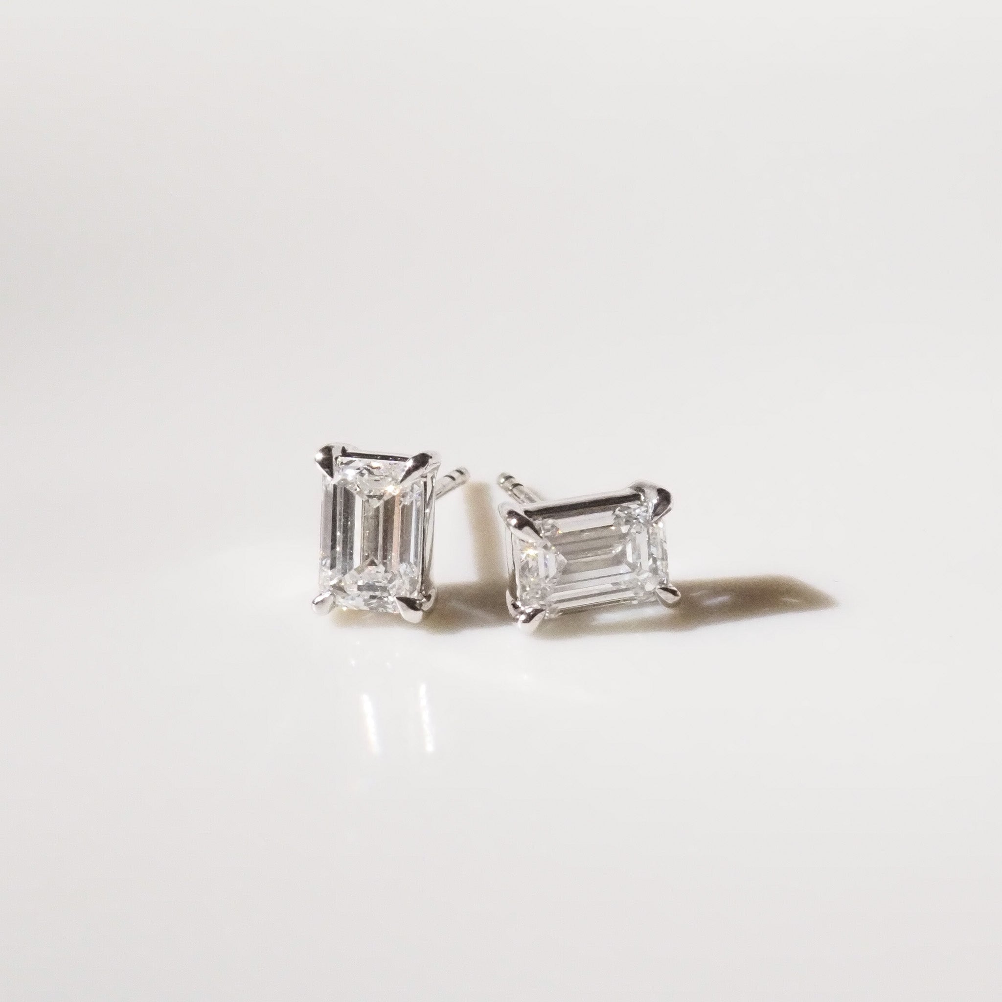 Pair of diamond stud earrings on a light gray background