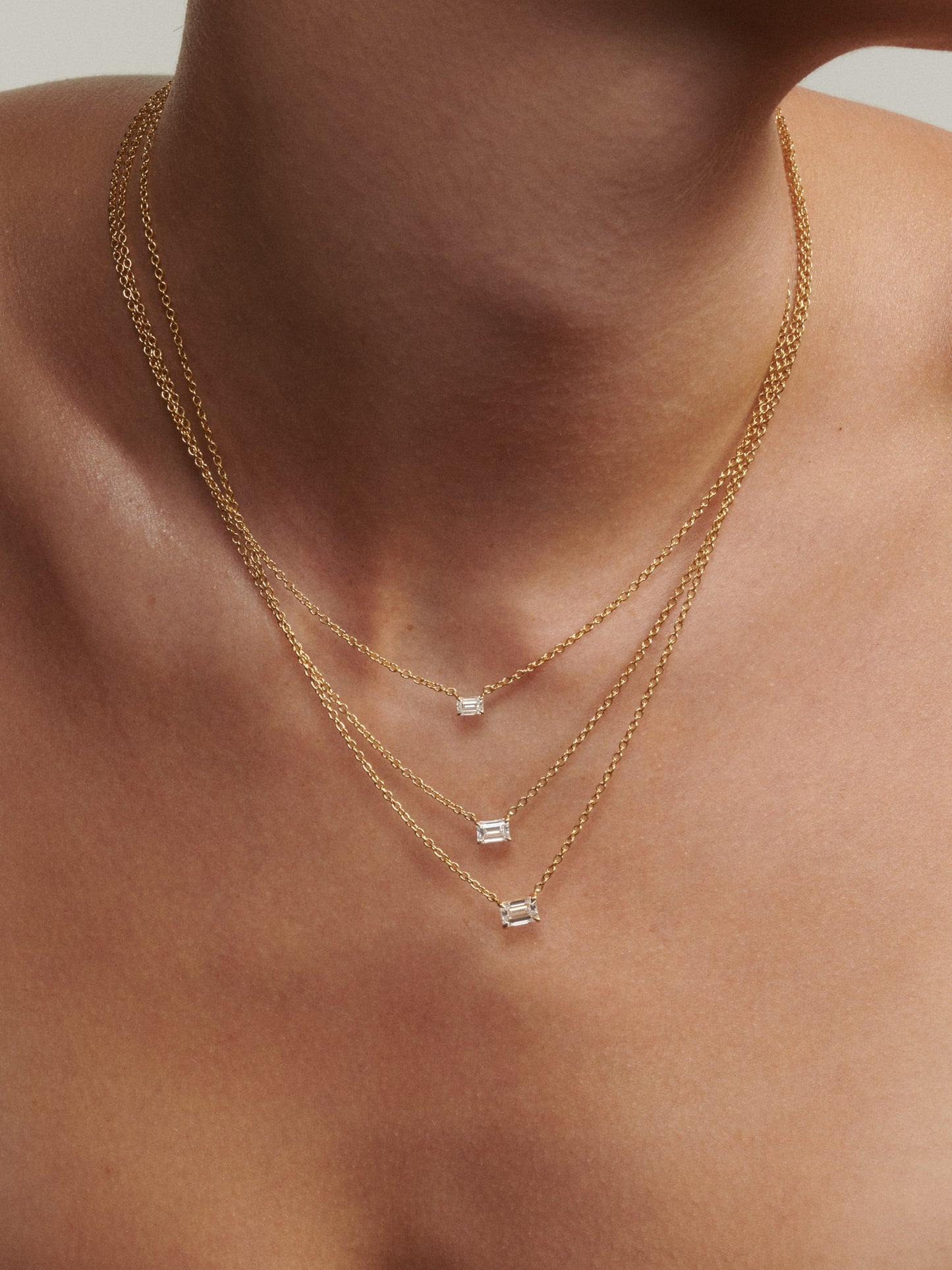 Gold necklaces with gemstones on a person's neck