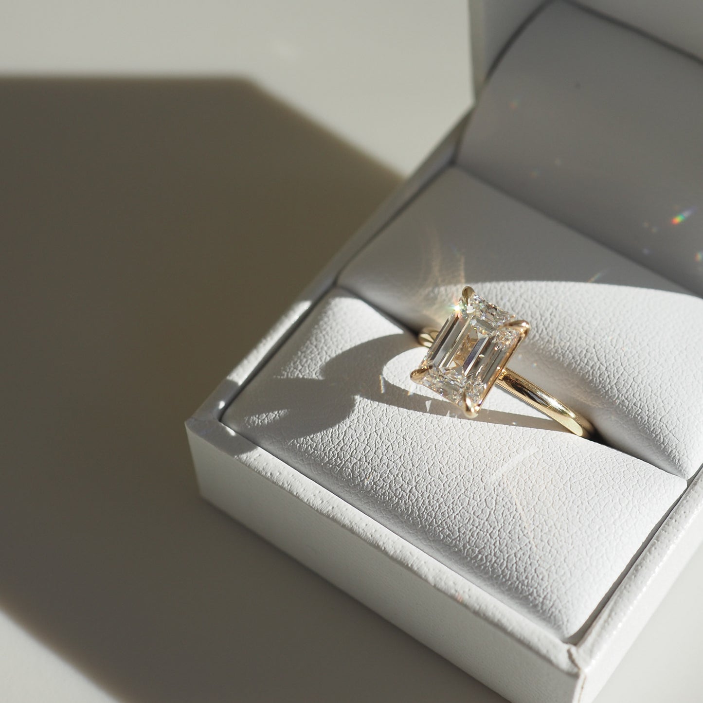 Emerald-cut diamond ring in a luxurious white box, showcasing elegance and sophistication in high-end jewellery.