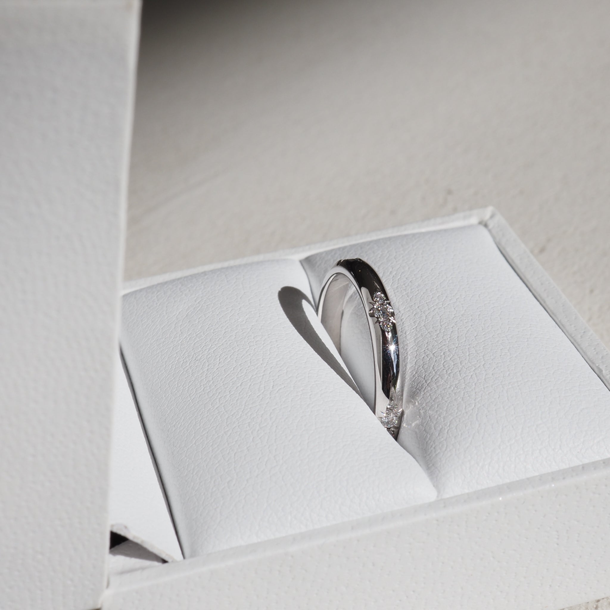 Luxury diamond ring in elegant white box, showcasing exquisite detail and craftsmanship. High-end jewellery elegance.