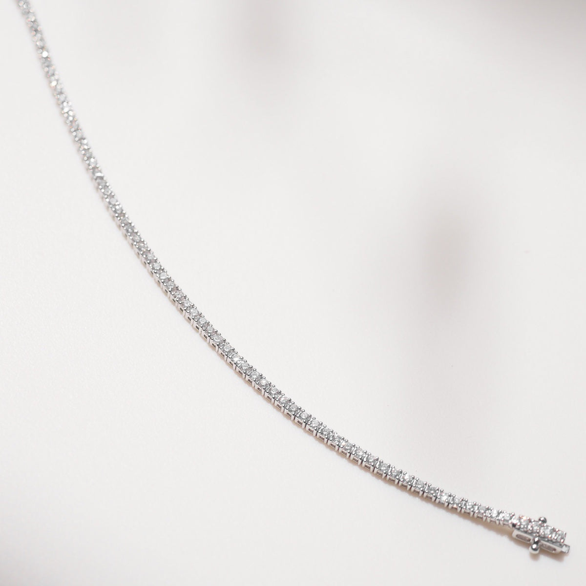 Close up of tennis bracelet on beige background
