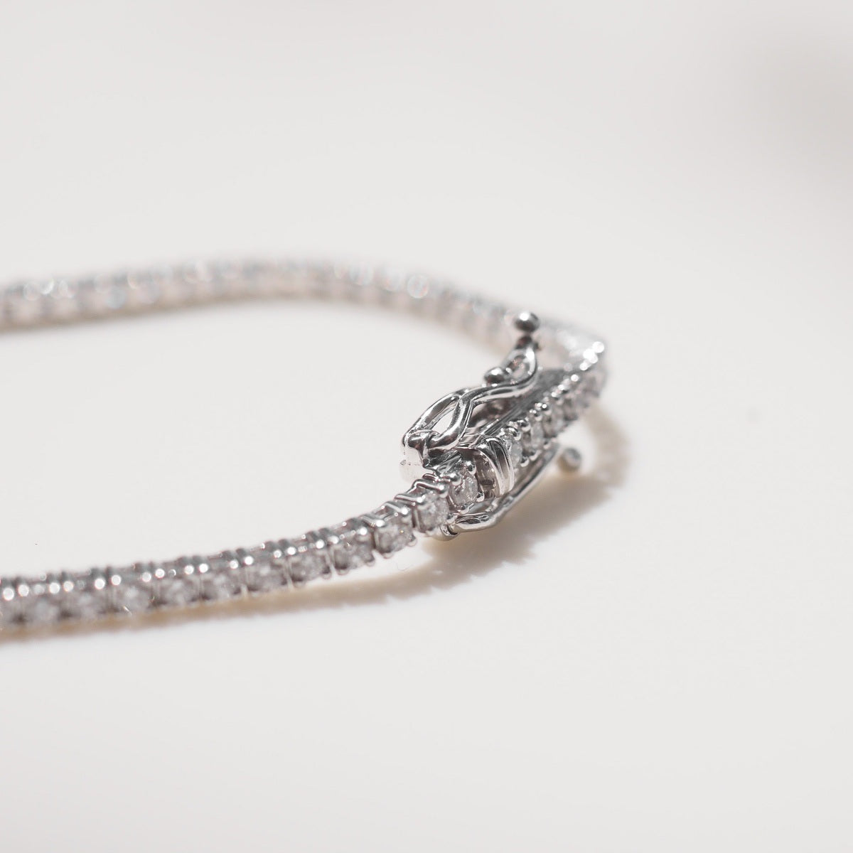 Silver bracelet with diamond accents on a light gray background
