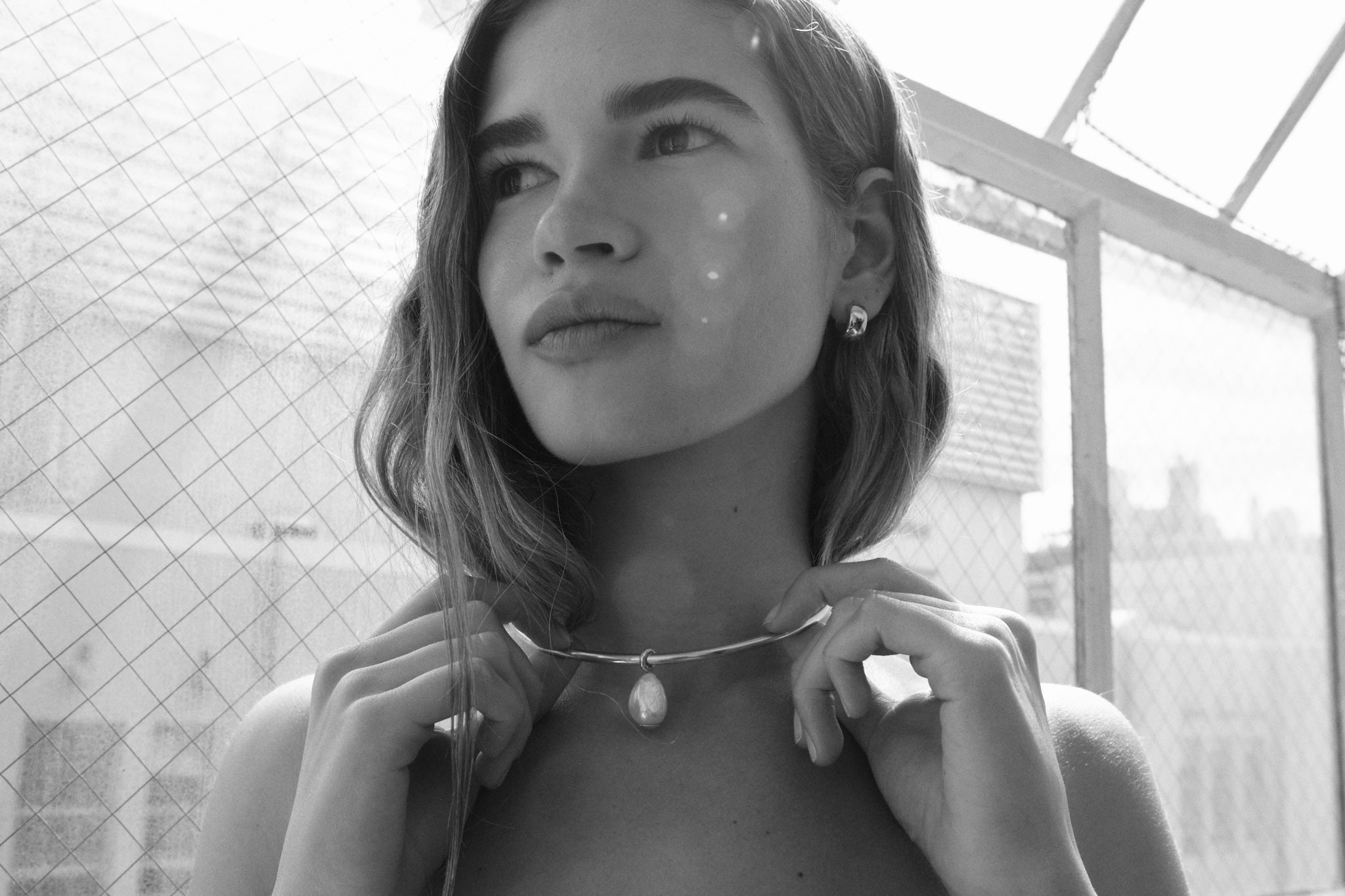 Woman wearing a necklace with a pendant in a black and white setting