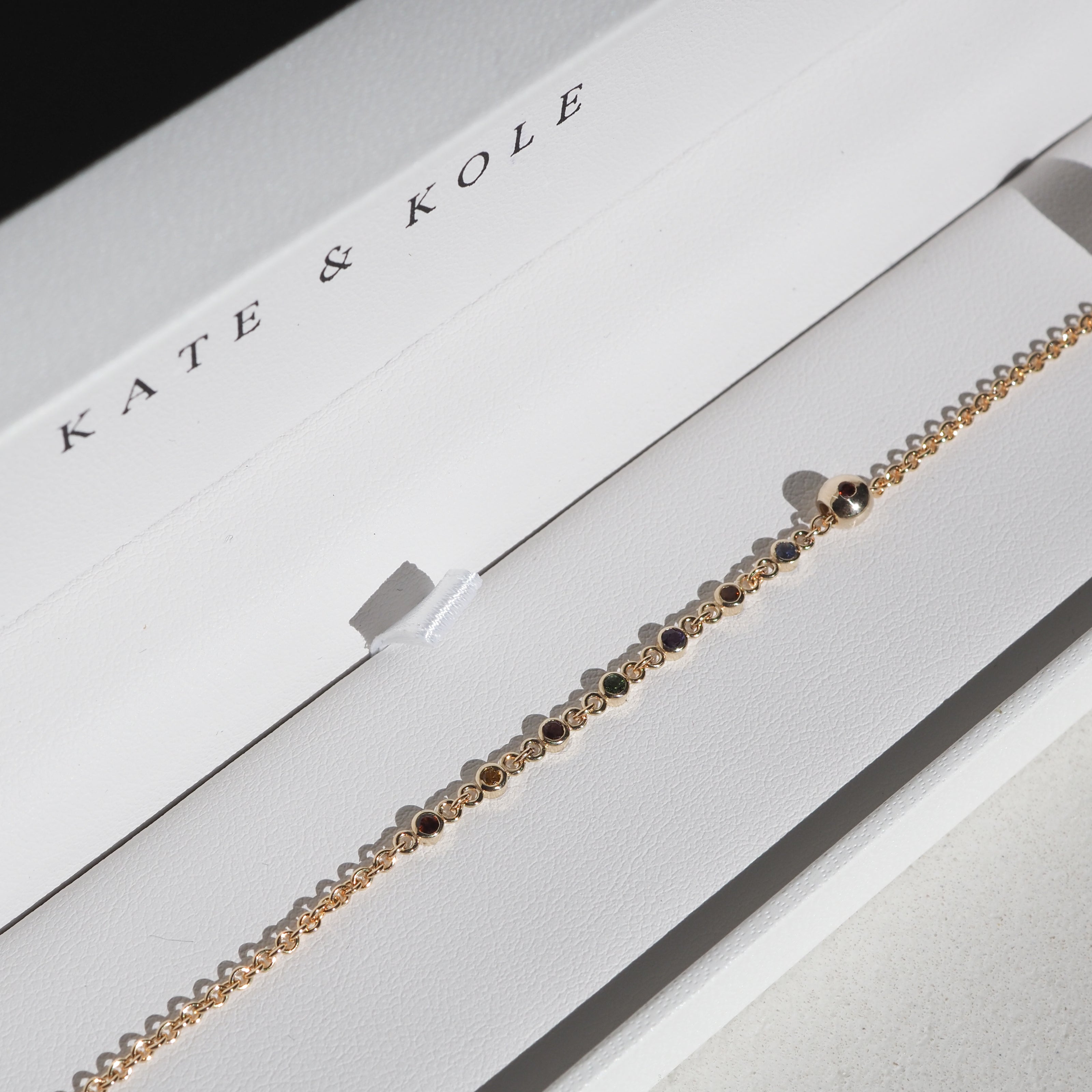 Elegant gold bracelet adorned with delicate gemstones in a Kate & Kole jewellery box, showcasing luxury and craftsmanship.