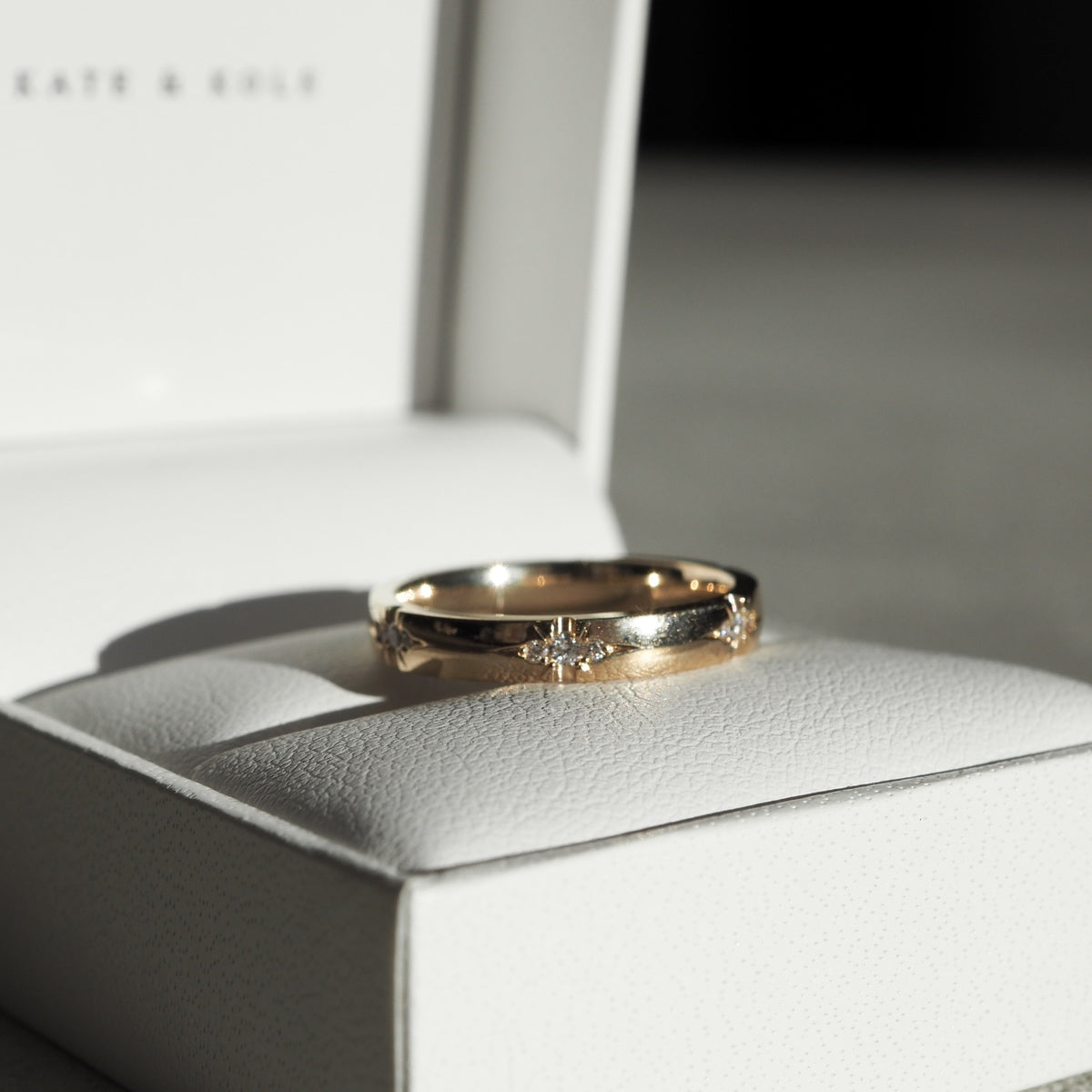 A solid 18ct yellow gold half-round band, set with six tiny trios of speciality set lab-grown diamonds. 3mm thick