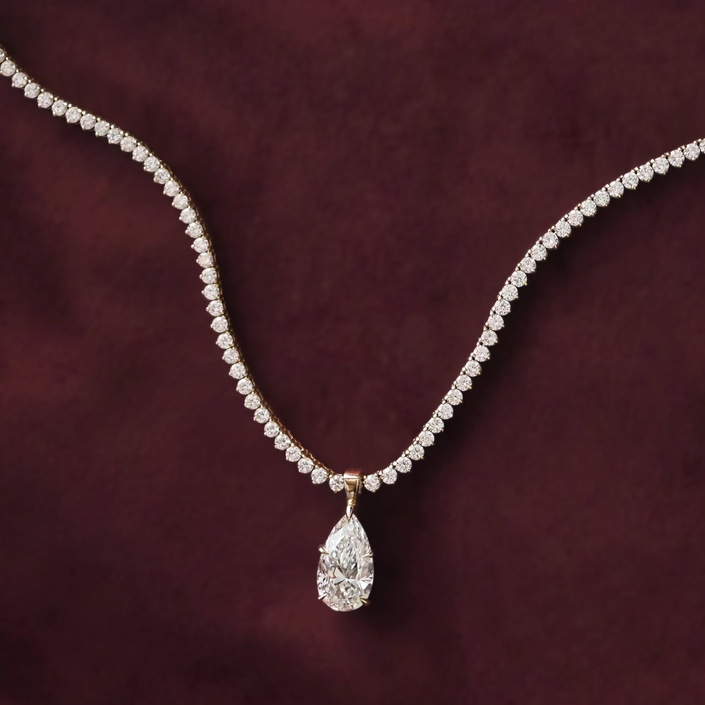 Diamond necklace with a teardrop pendant on a dark purple background